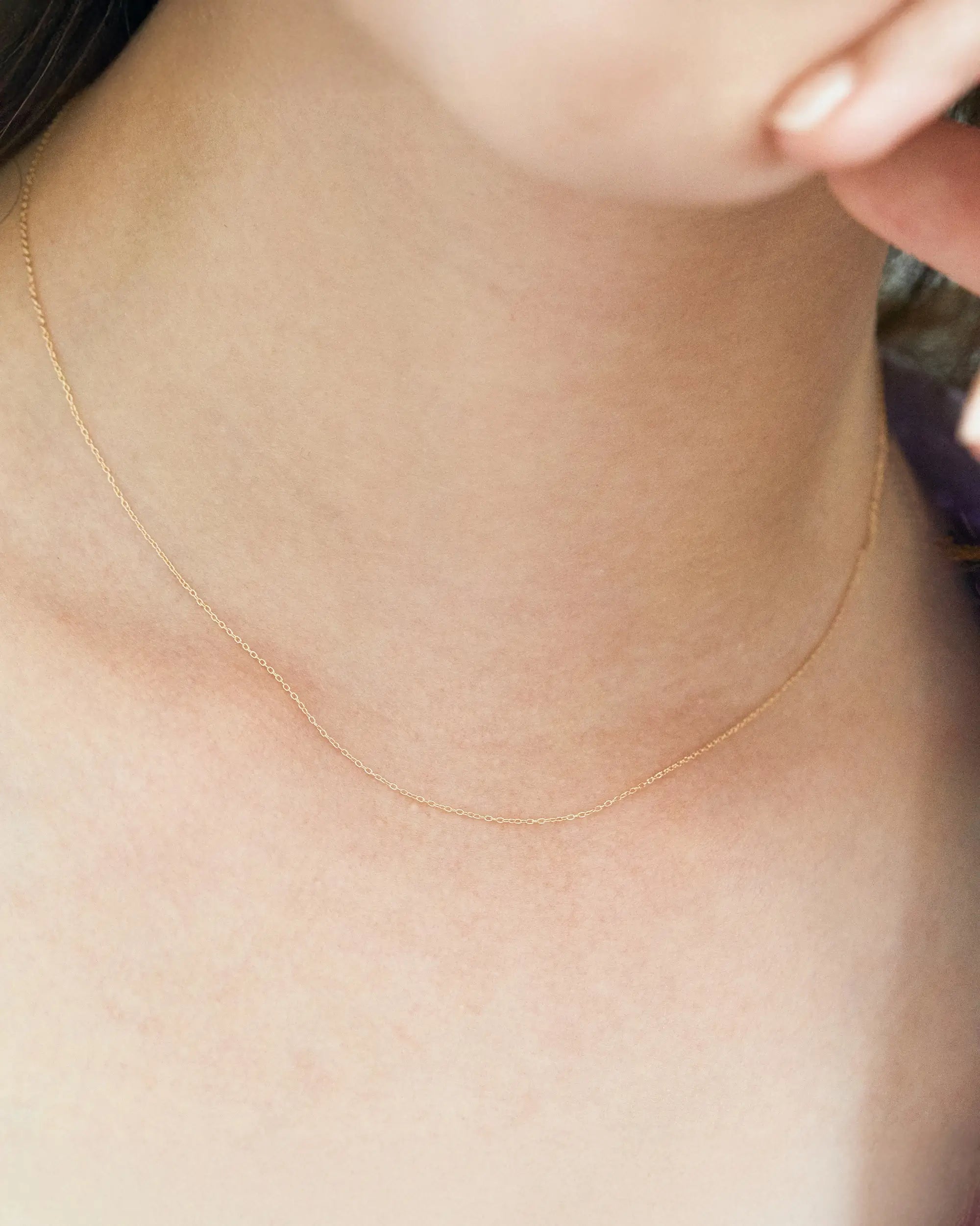 10Kイエローゴールド チェーンネックレス 着用アップ - 鎖骨に沿って柔らかなカーブを描く上品な輝き