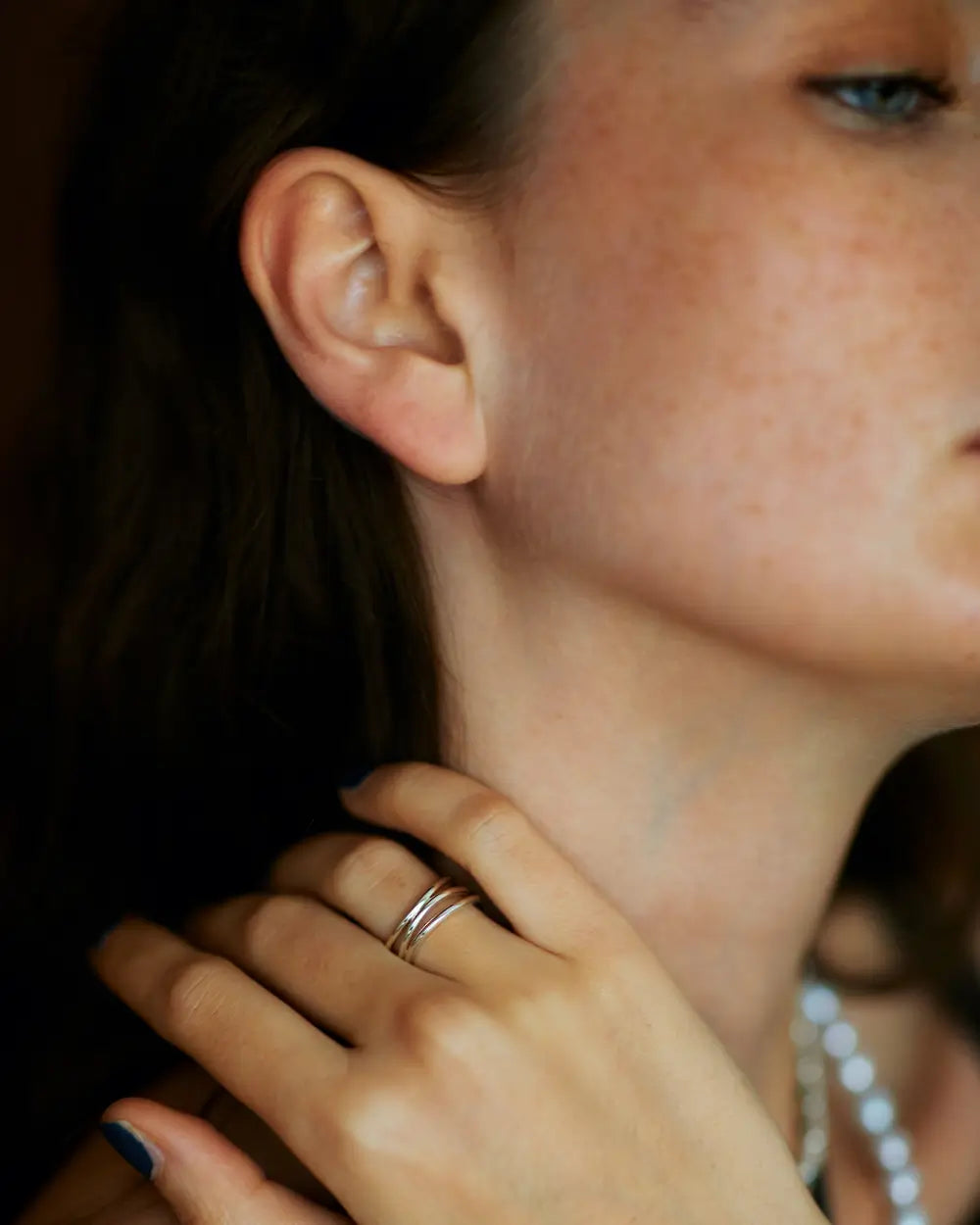 シルバー925 3連ウェーブリング着用イメージ。首元に手を添えたエレガントな雰囲気。