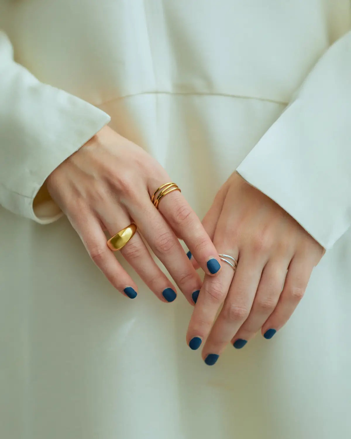 白の衣装に映えるゴールドの3ロウウェーブリング。1つで重ね付けしたように見える華やかな幅広デザイン。