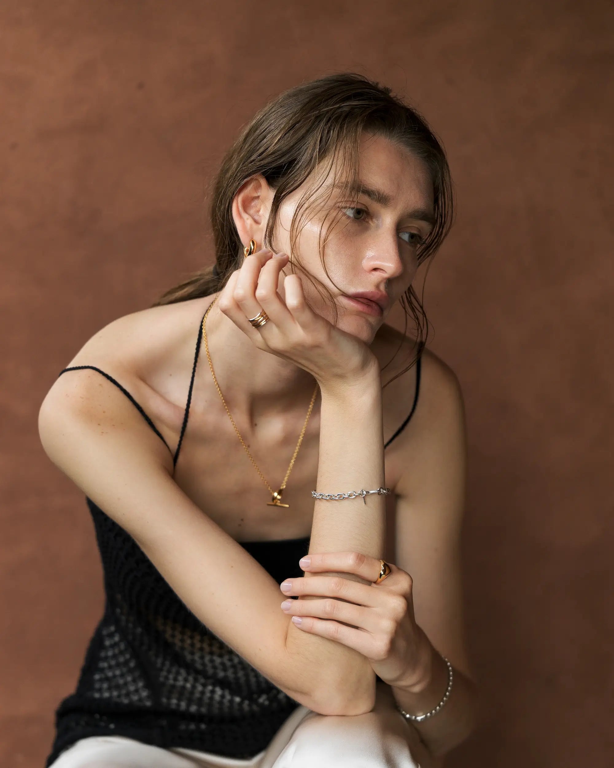 女性モデルが中指に着用した、おしゃれなバイカラー5ロウウェーブリング。シンプルで存在感のあるデザインは、つけっぱなしにも最適。錆びないシルバー925に18金K18コーティングを施した人気のレディース指輪です。