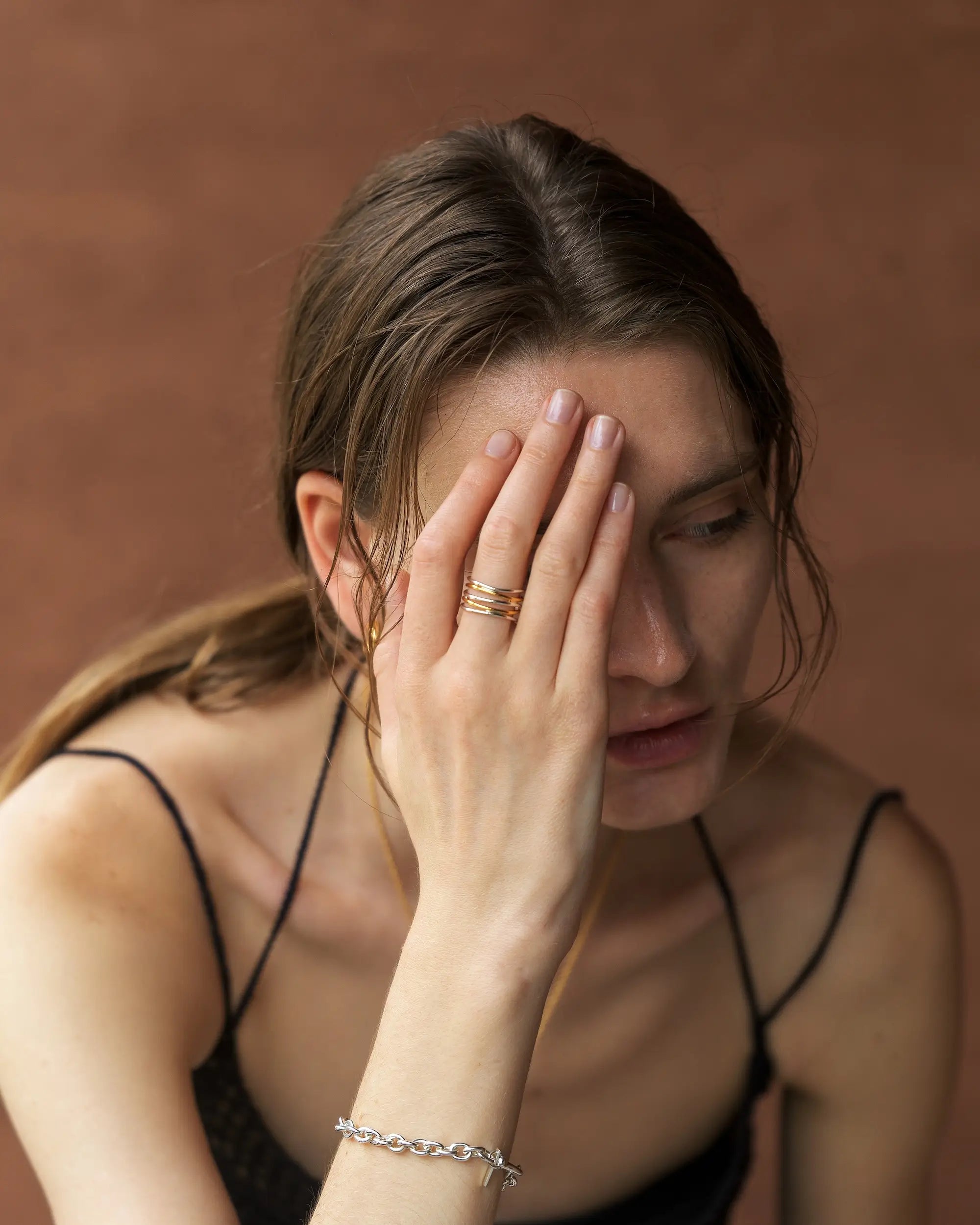 女性モデルが中指に着用した、おしゃれなバイカラー5ロウウェーブリング。シンプルで存在感のあるデザインは、つけっぱなしにも最適。錆びないシルバー925に18金K18コーティングを施した人気のレディース指輪です。