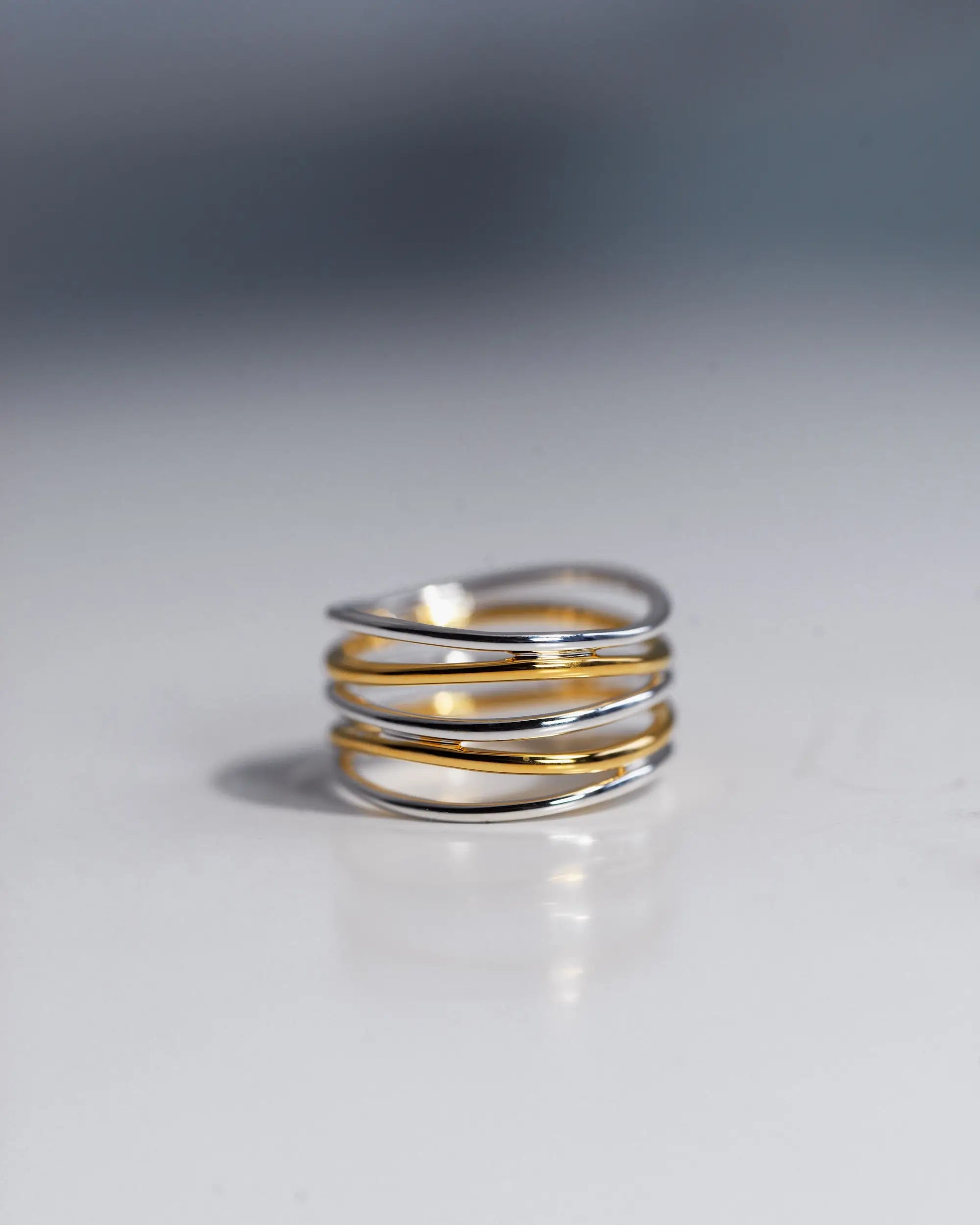 バイカラーの5ロウウェーブリング。人差し指や中指に人気のデザインで、シンプルながらも存在感があります。つけっぱなしでも錆びないシルバー925素材に18金K18コーティングを施しており、メンズ・レディースのペアリングとしても最適なシルバーアクセサリーブランドの指輪です。