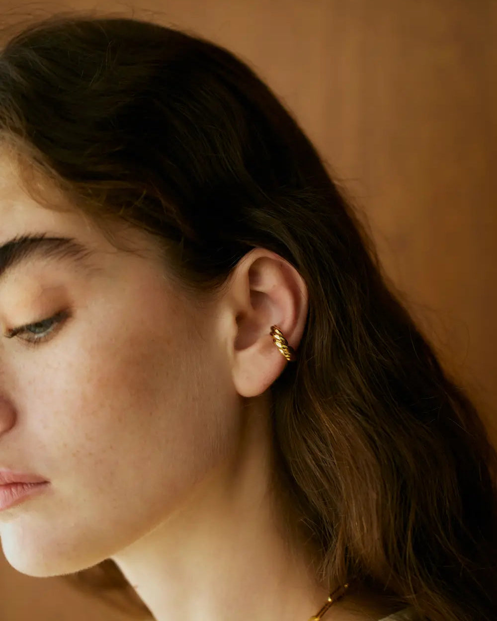 ウェーブイヤーカフ(ゴールド)の着用横顔。緩やかに波打つラインが横顔にニュアンスを生む、金属アレルギーに配慮した高品質ジュエリー。