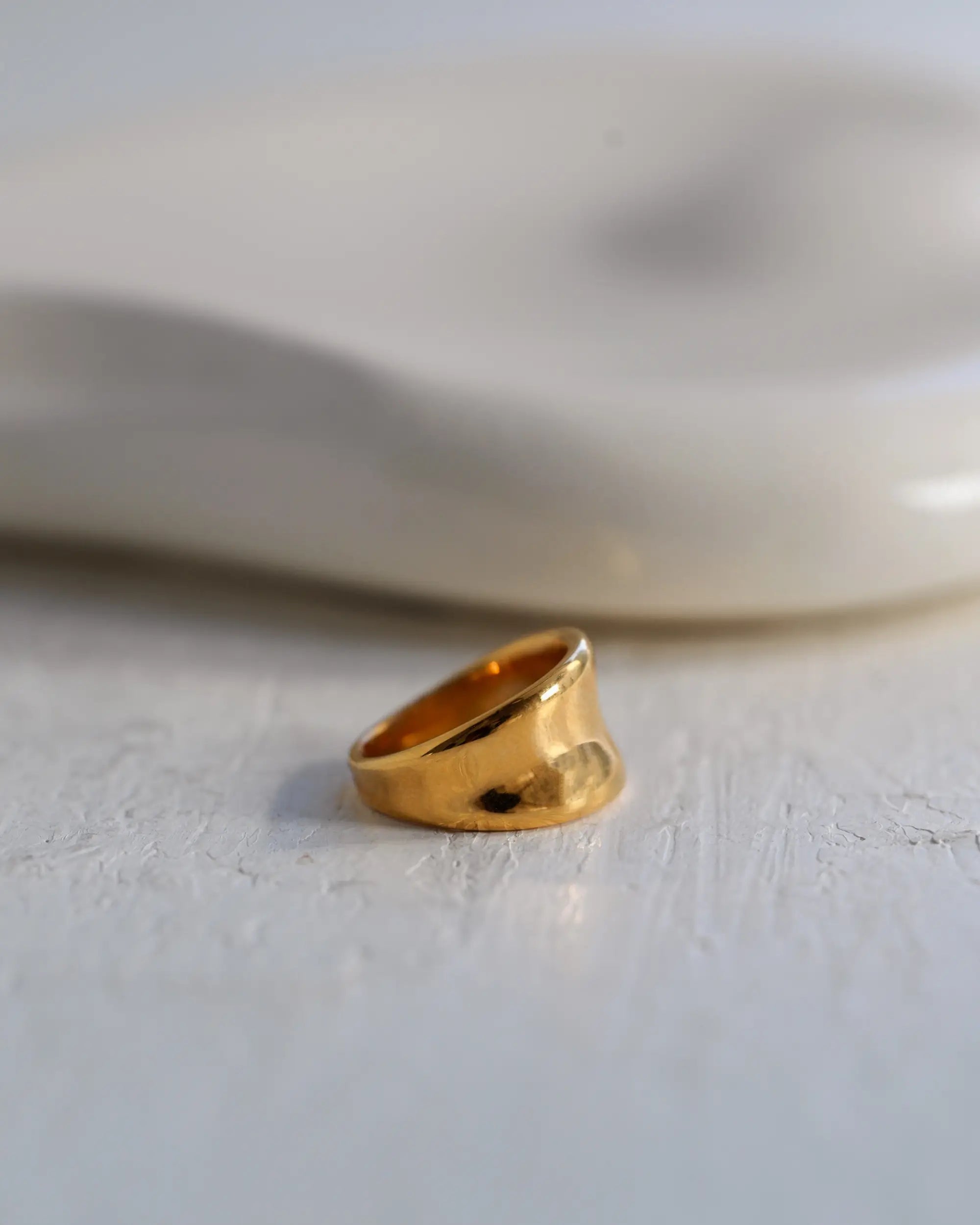 柔らかな陰影の中に浮かび上がる、Botanical Ring(ボタニカルリング)ゴールドの接写画像。