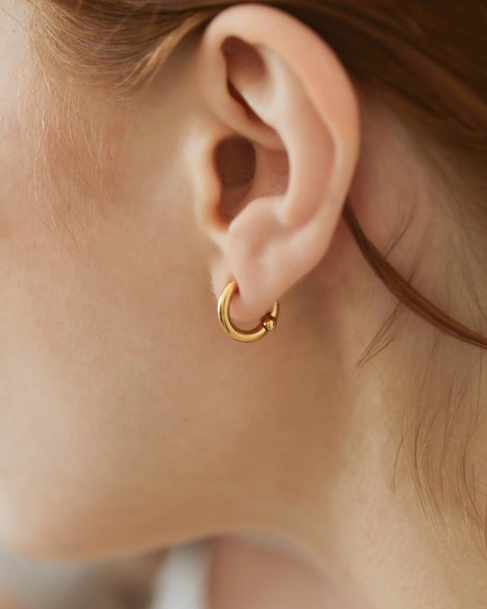 クラシックフープイヤリング(ゴールド)の耳元ドアップ。ネジやクリップが見えず、まるで本物のピアスのような見え方を実現。