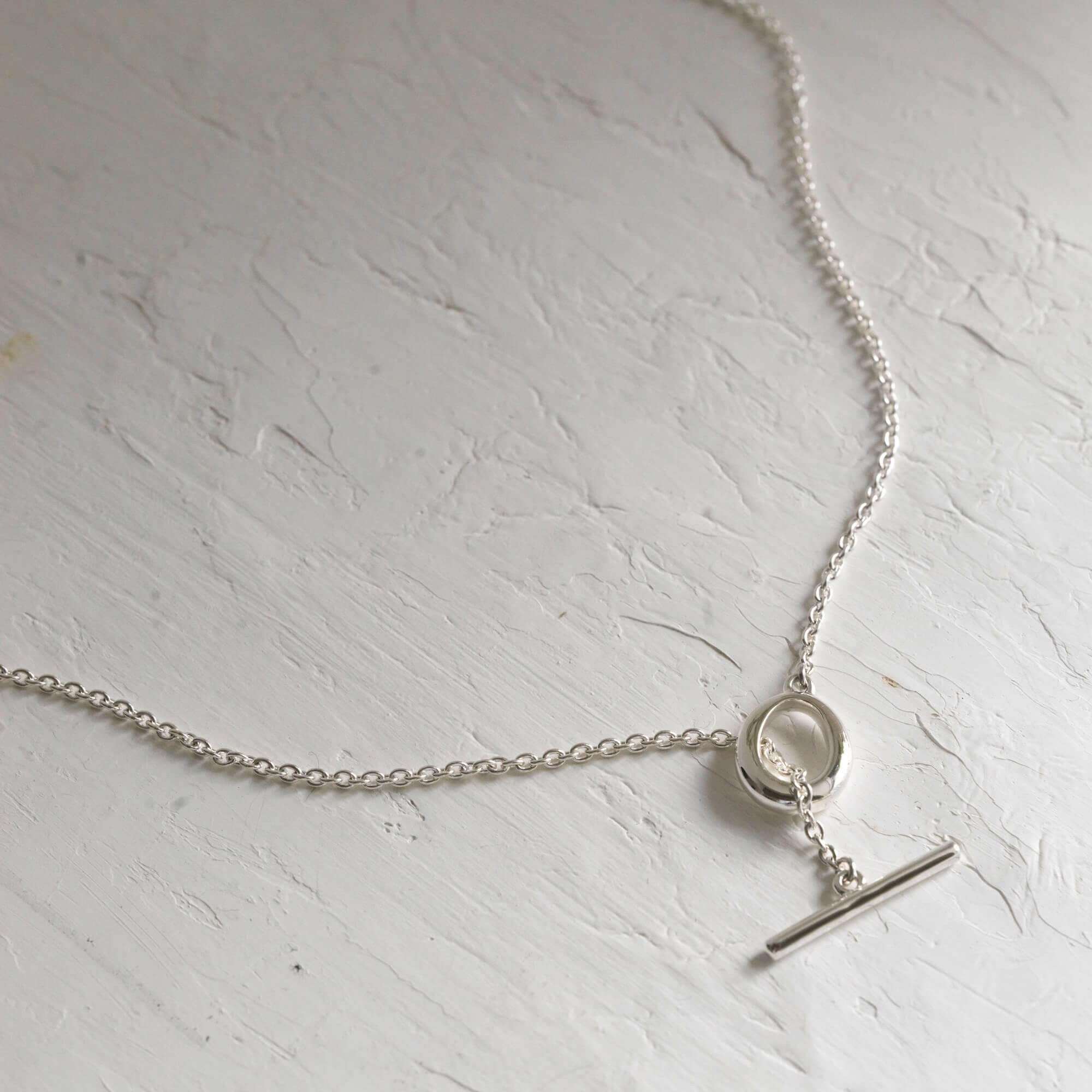 デュードロップネックレス シルバー マンテルパーツ | ブランド刻印入りの有機的なトグル留め具