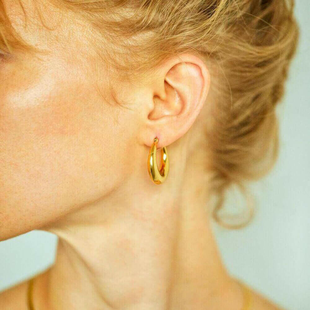 ドロップフープピアス M ゴールド 着用画像 | シンプルな装いに華やかさを添える存在感のあるゴールドピアス