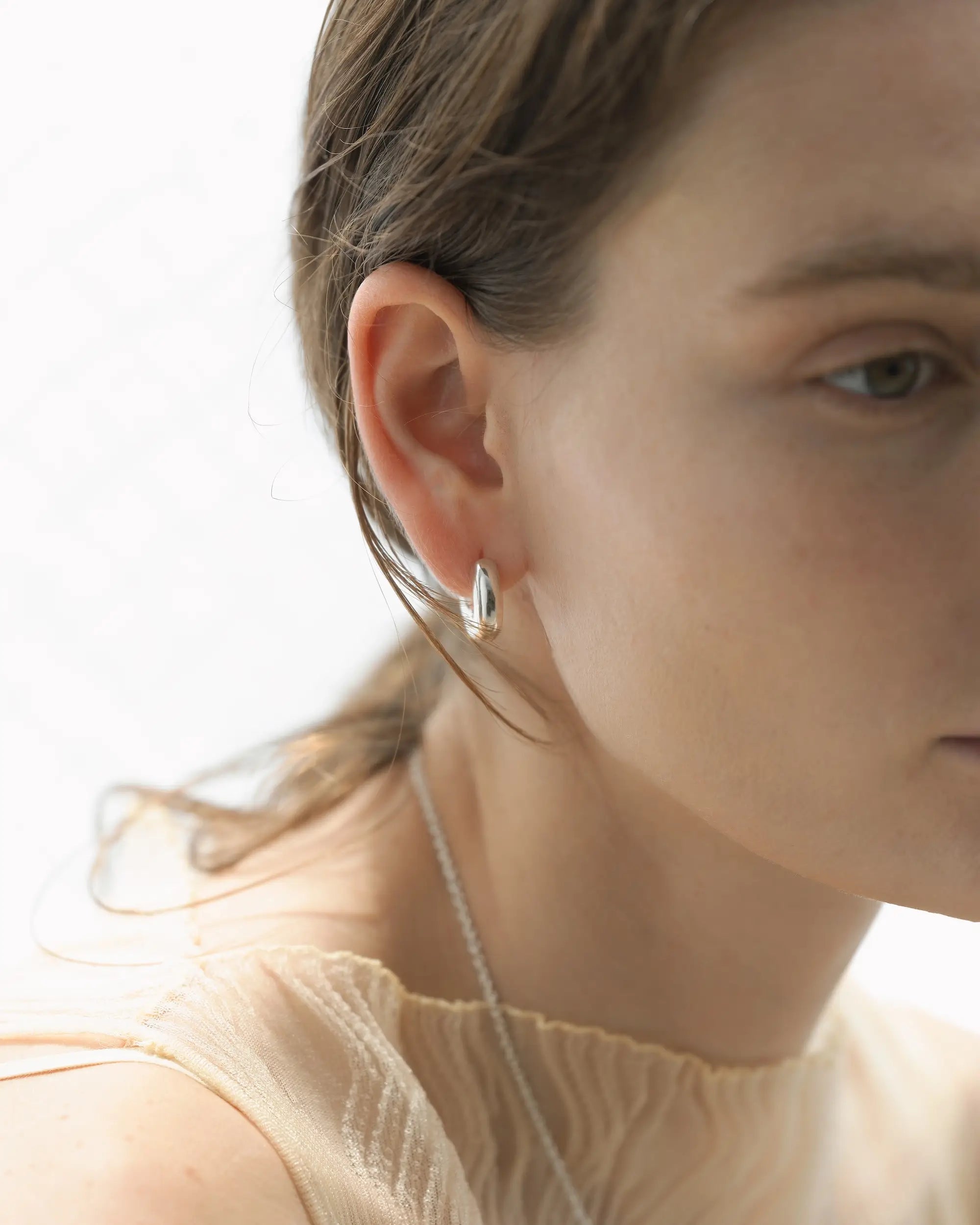 フラグメントフープピアス シルバー アップ | 職人の手仕事を感じさせる滑らかなテクスチャ