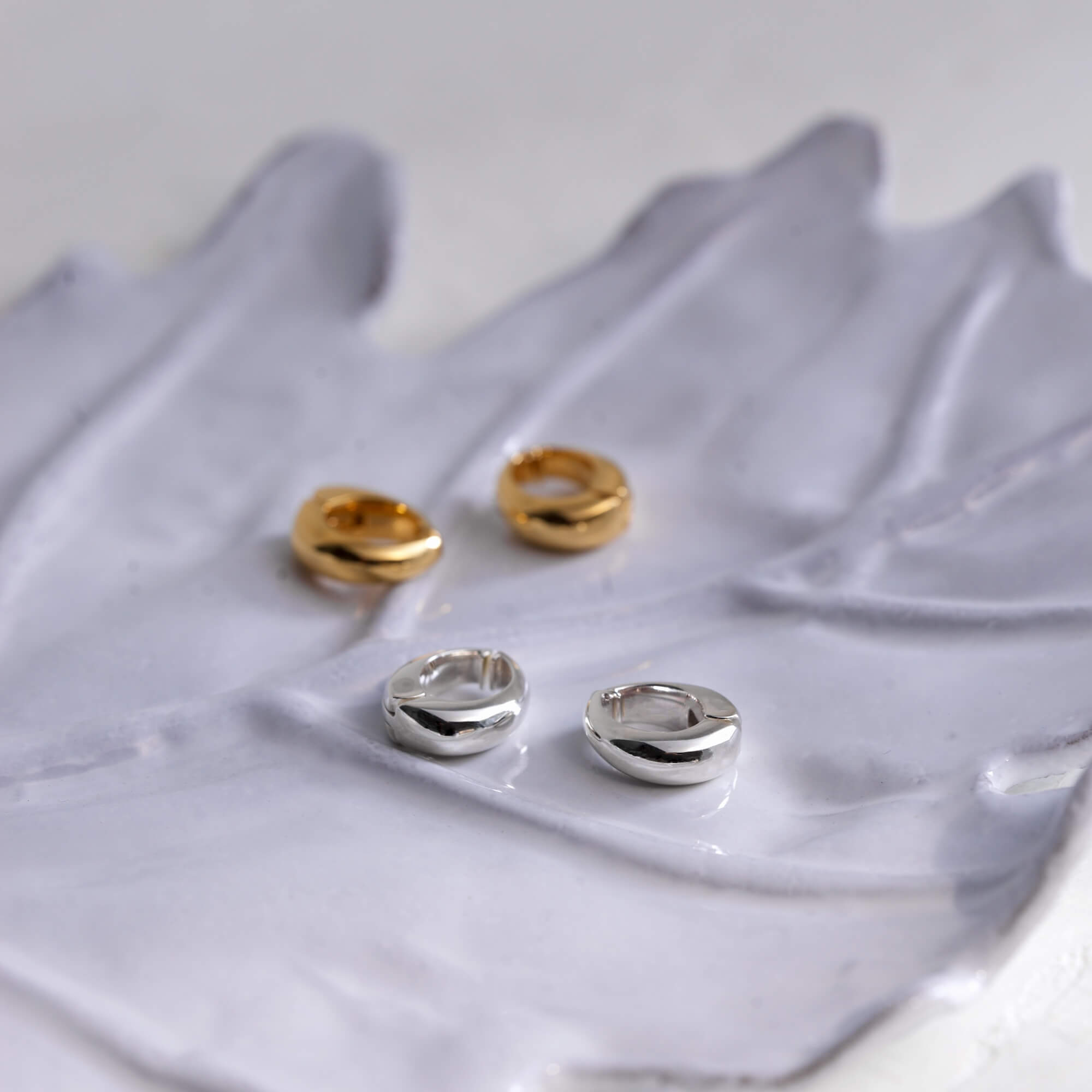 ヒンジドフープイヤリング M ゴールド・シルバー 置き画 | 有機的な曲線美が際立つモードなノンホールピアス