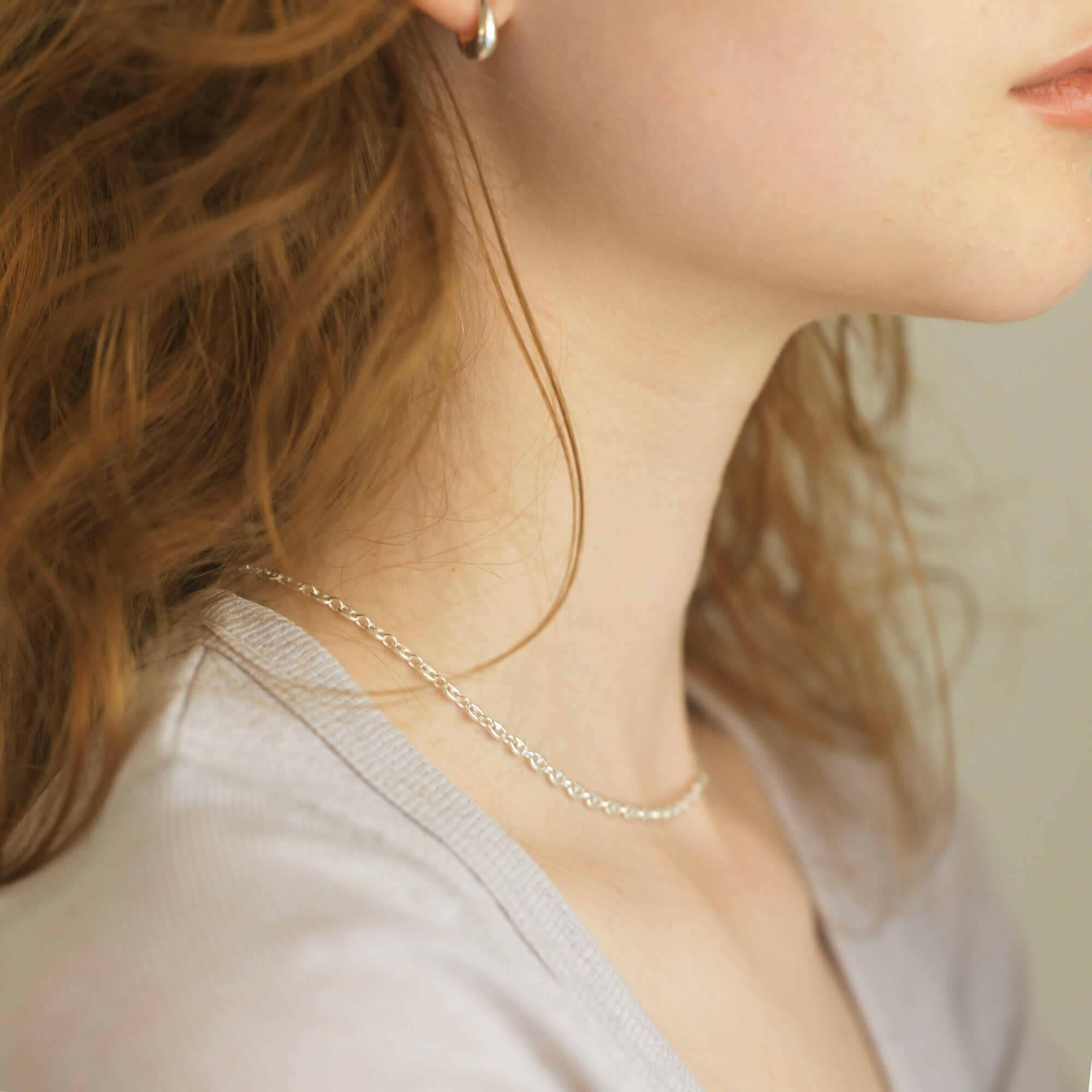 マリーナリンクチェーンネックレス 横顔 | 面取り加工が光を反射して艶めくシルバーネックレス