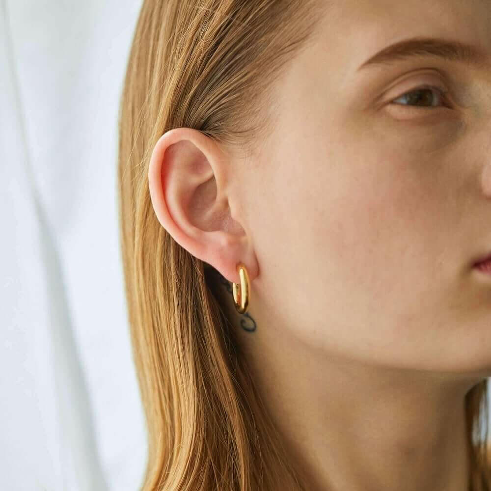 オーバルフープピアス M ゴールド 横顔 | 存在感のあるボリュームと18Kコーティングの華やかさ