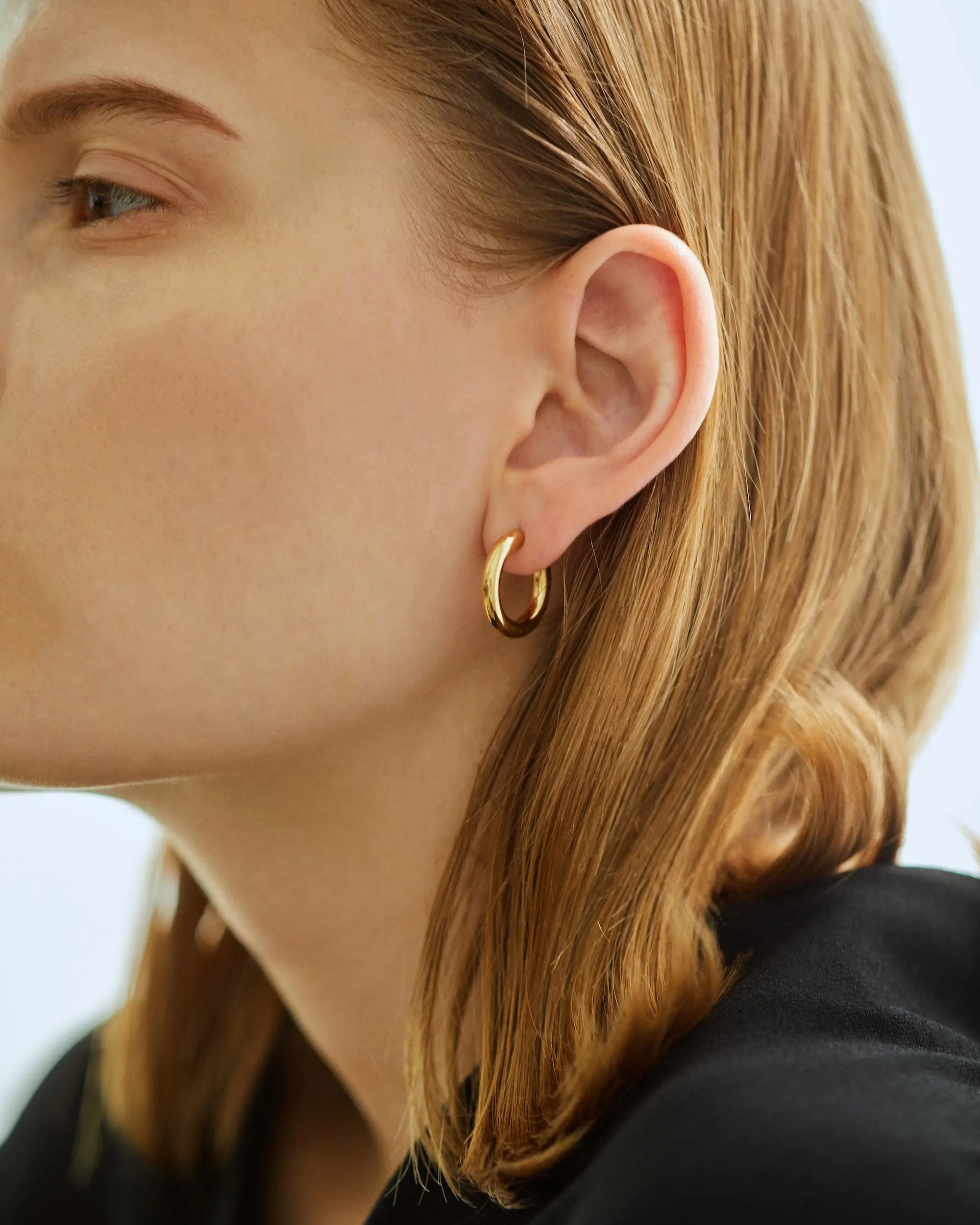 ゴールドのオーバルフープピアス着用画像。大ぶりでありながら片耳約2.5gの軽やかな着け心地で、長時間の着用でも痛くなりにくい設計。
