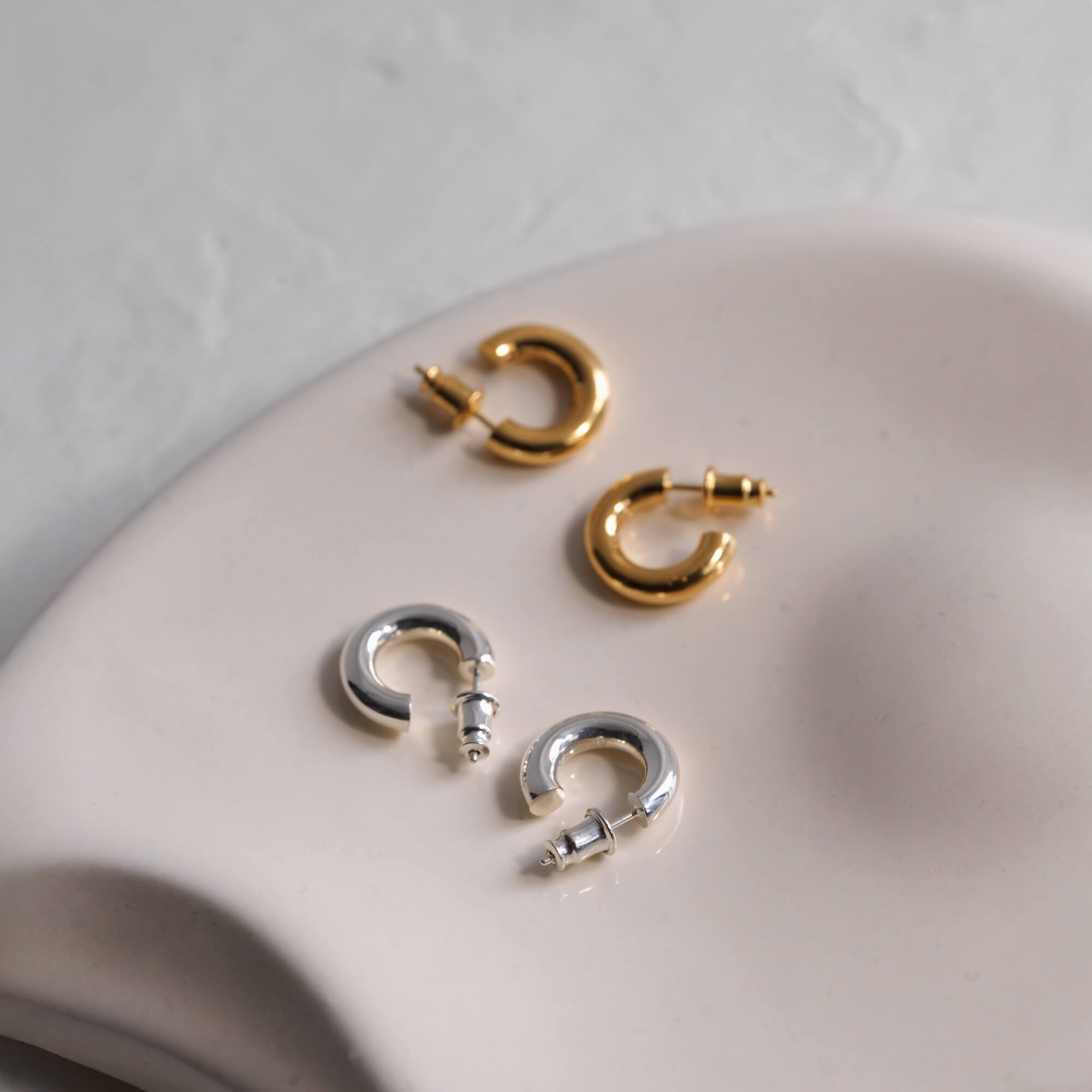 オーバルフープピアス S 置き画 | 縦長シルエットが美しいシルバー925と18Kコーティングの比較