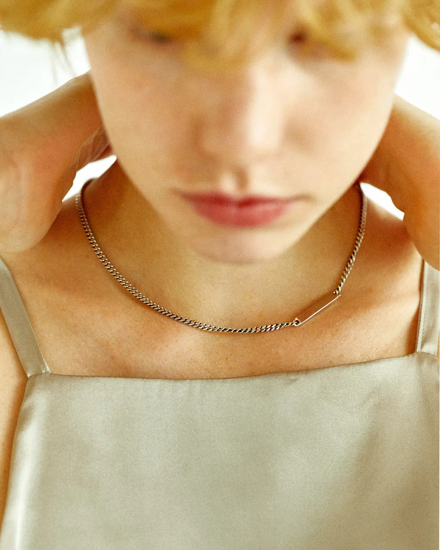 プレートチェーンネックレス(シルバー925)着用画像 - 光を強く反射し首元にモダンなリズムを生むフラットプレート
