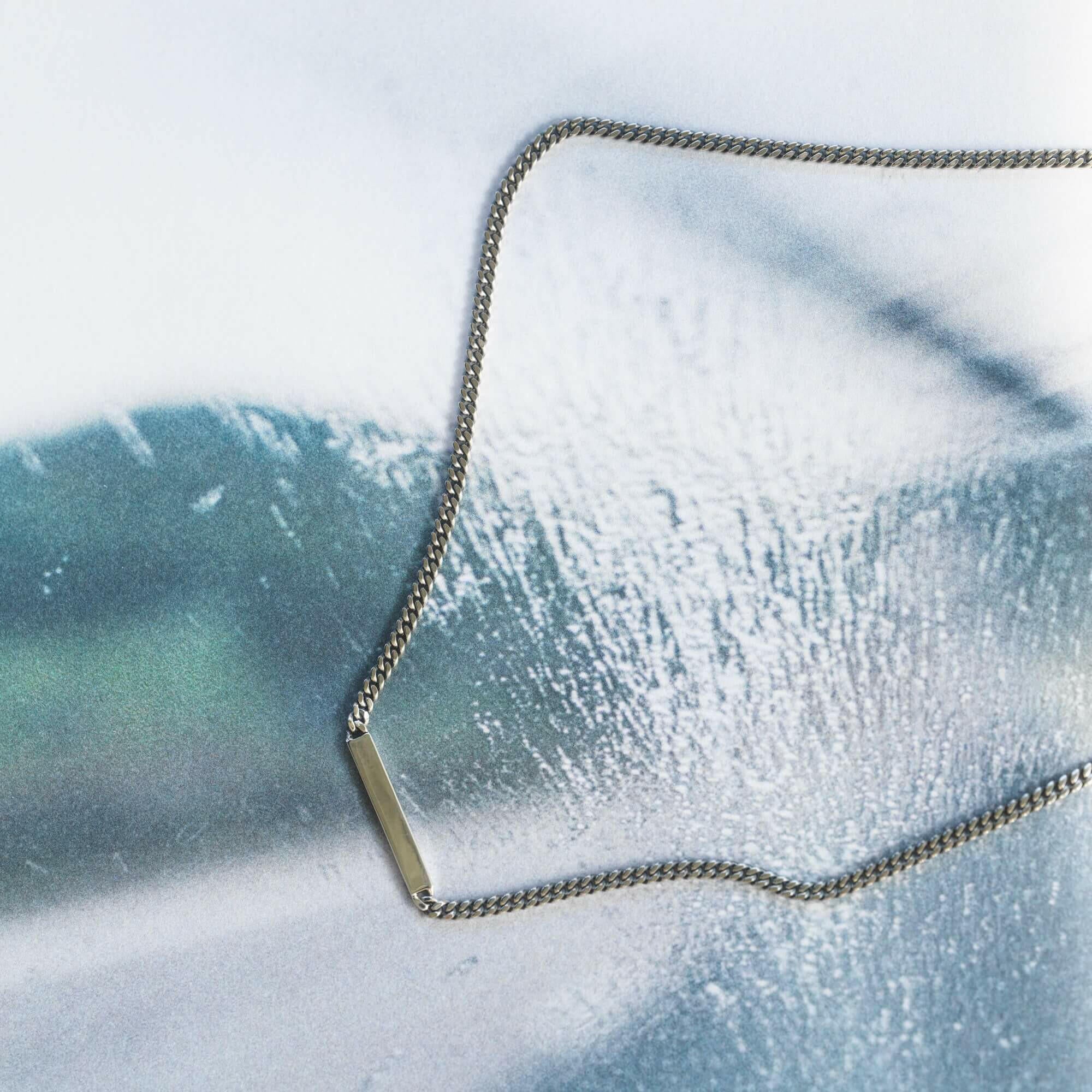 プレートチェーンネックレス シルバー 置き画 | 細身の喜平チェーンと鏡面プレートが輝く上品なデザイン