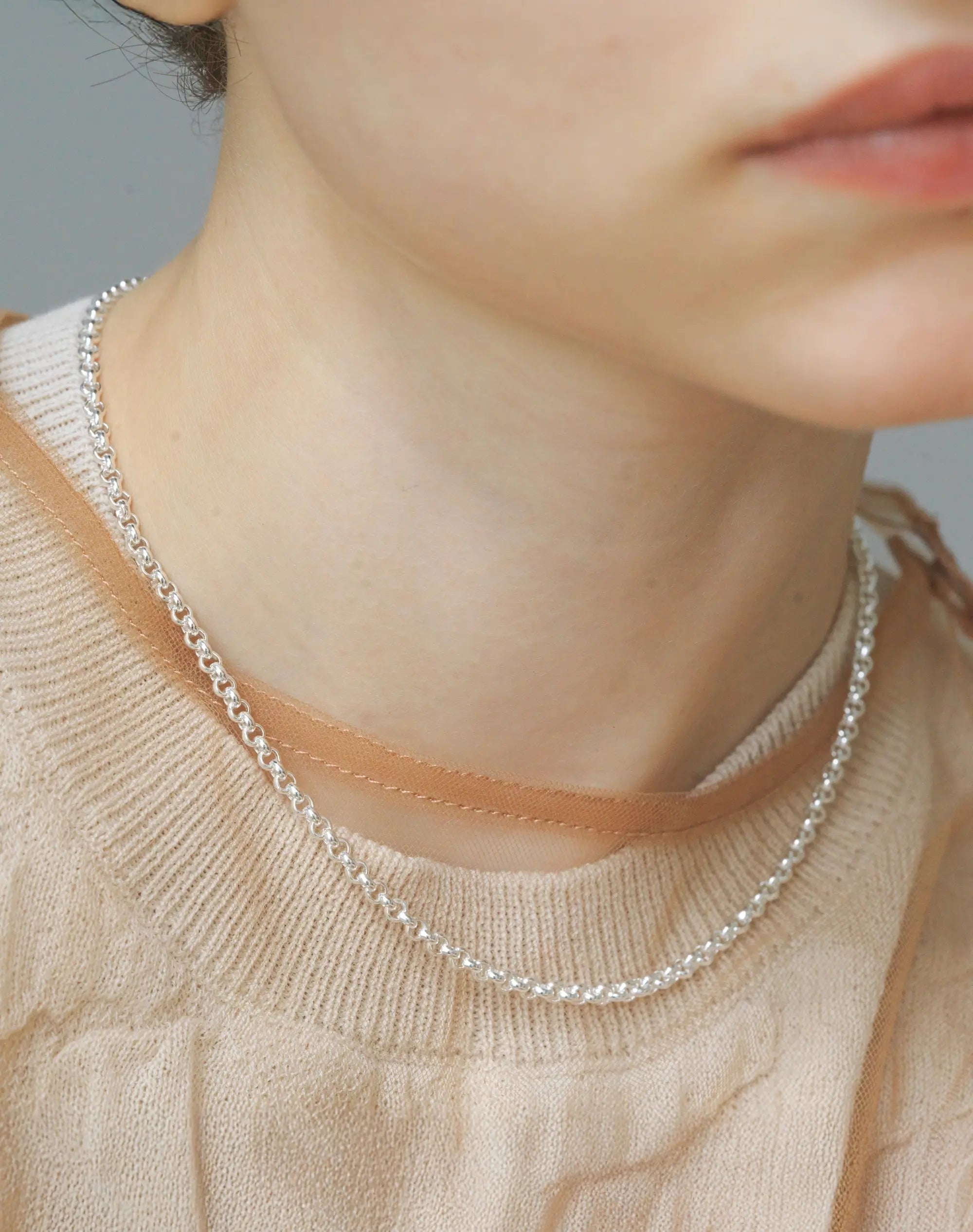 リカランスチェーンネックレス(シルバー)着用画像 - 滑らかなチェーンが光を反射し艶めくデコルテ