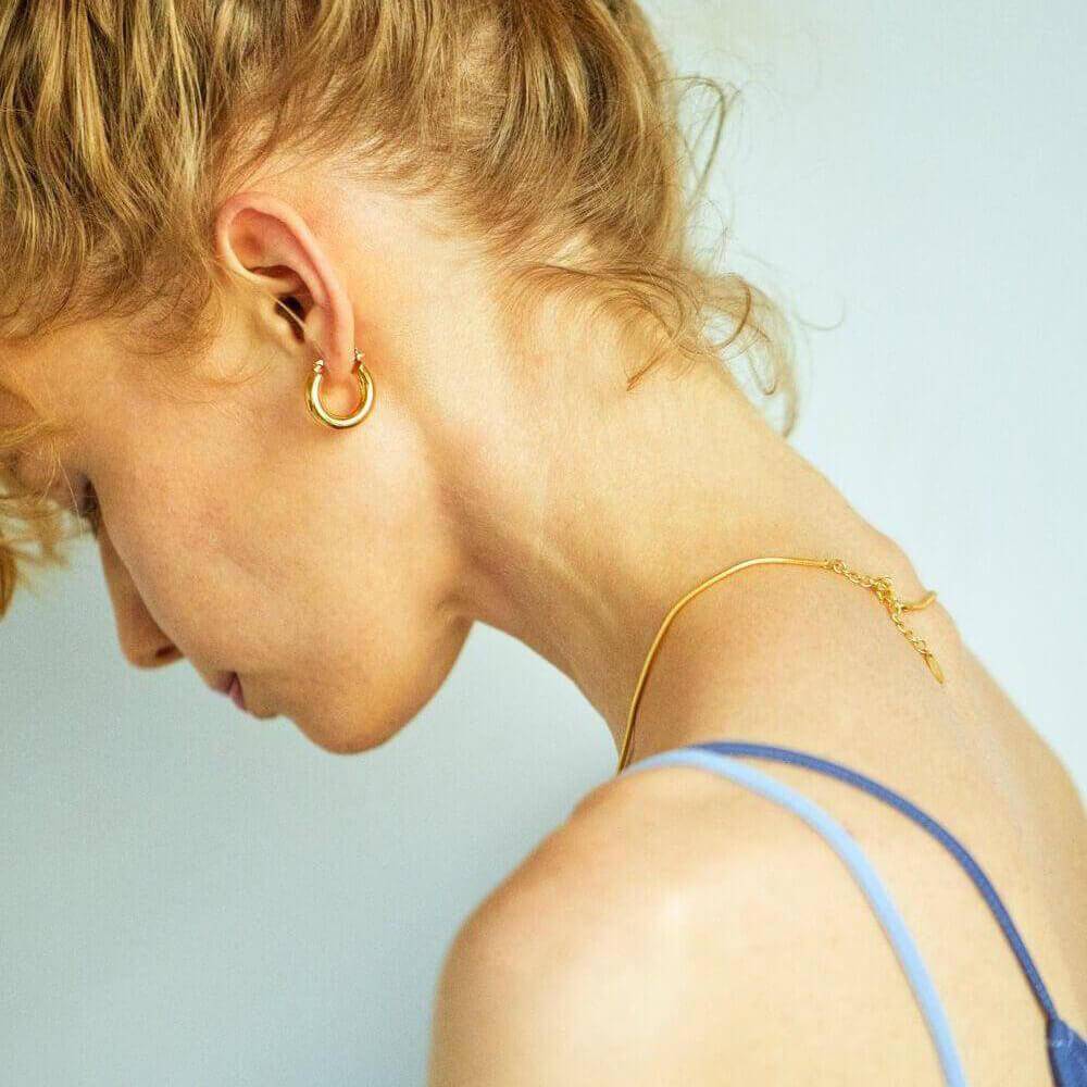 ラウンドスネークネックレス ゴールド コーディネート | デコルテを明るく彩るエレガントなチェーンネックレス