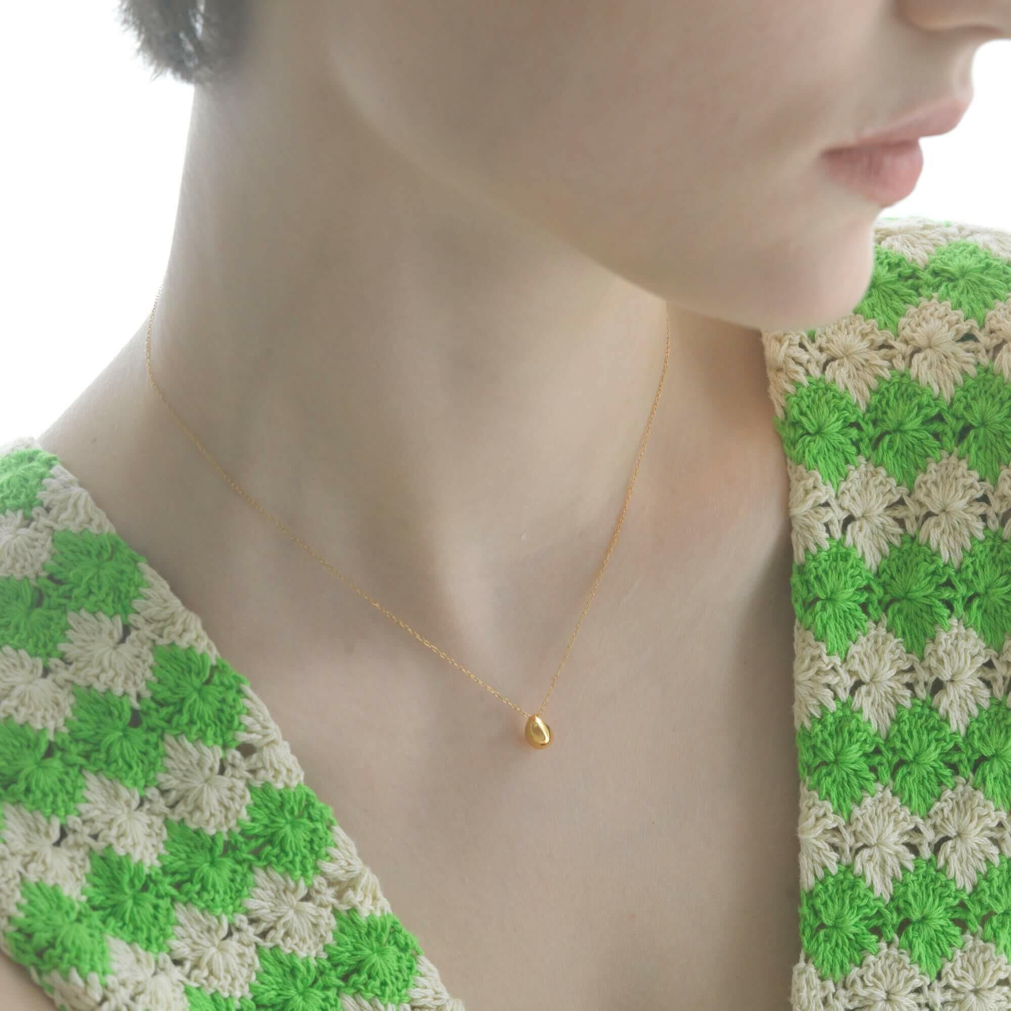 ティアドロップネックレス ゴールド 着用 | カジュアルなニットにも映える小ぶりな雫型モチーフ