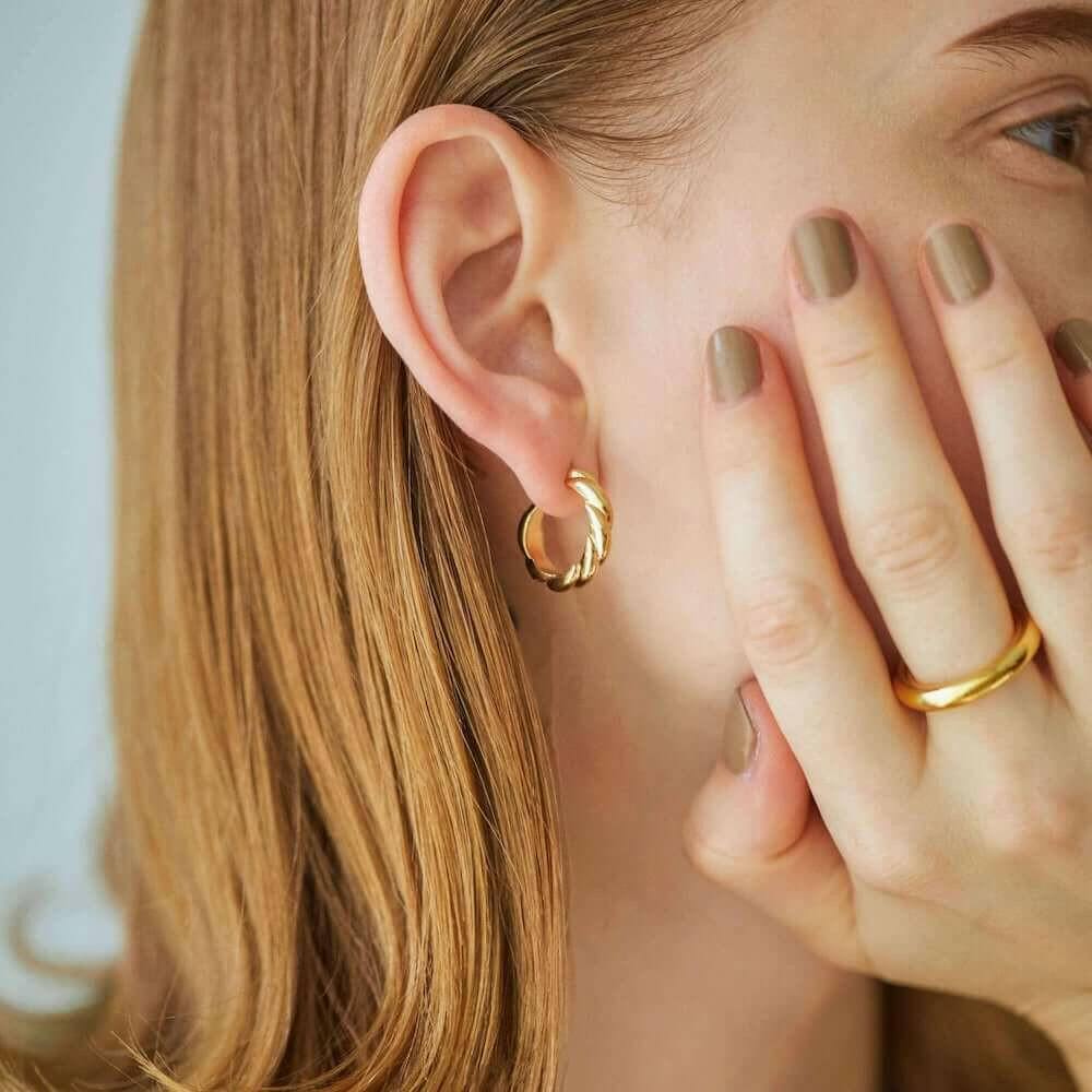 ウェーブフープピアス M ゴールド 横顔 | 指先のネイルやリングとも相性の良い18Kコーティングピアス