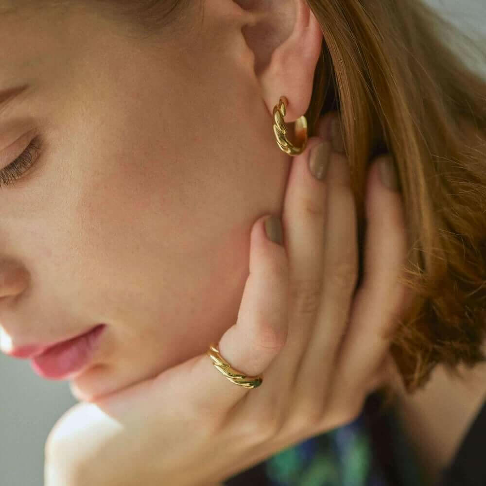 ウェーブフープピアス M ゴールド 着用 | ドラマチックな陰影を生み出すツイストフォルムの魅力