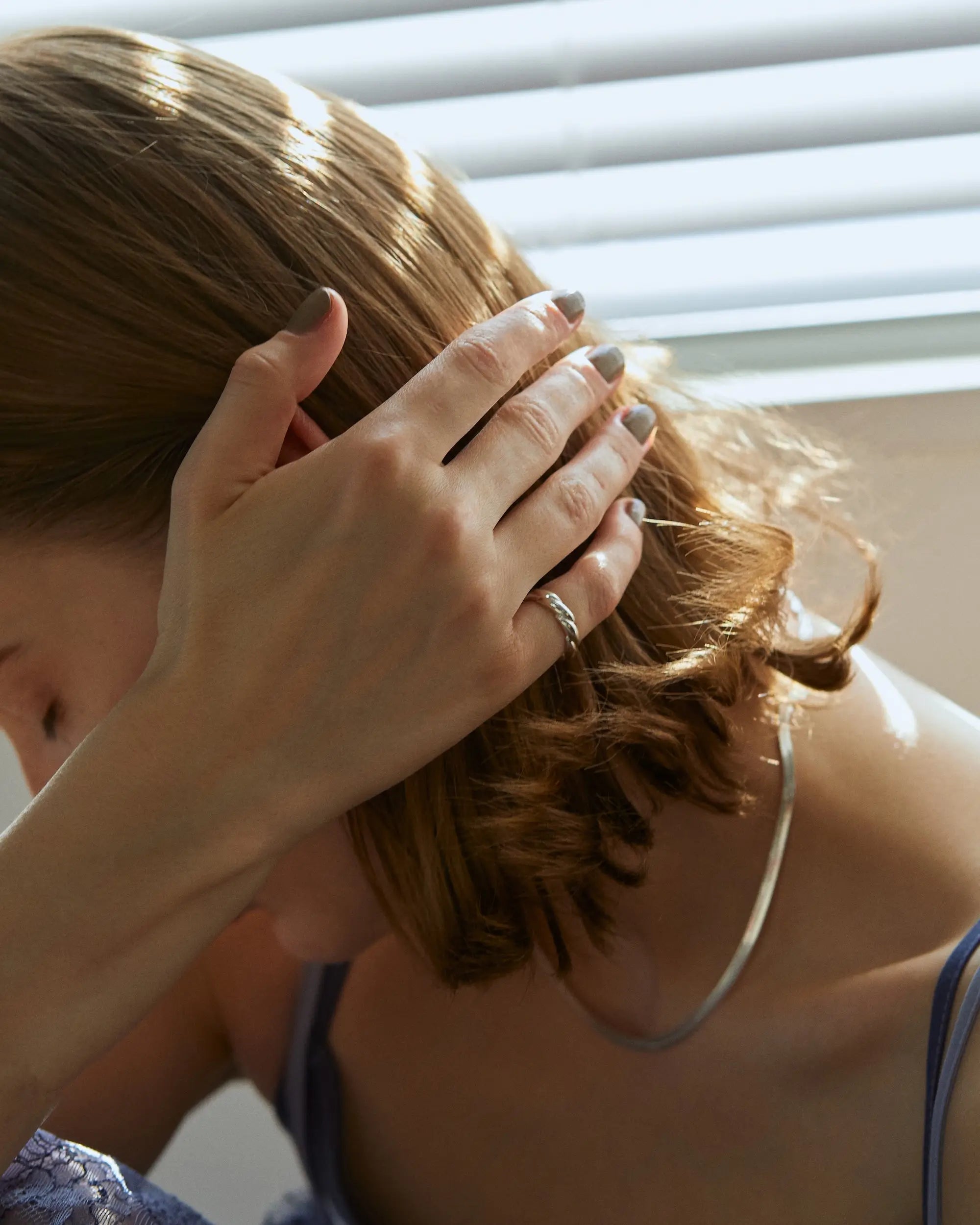 ウェーブリング(シルバー)を着用した手元の後ろ姿。直線的なリングにはない柔らかな立体感が肌に心地よく馴染みます。