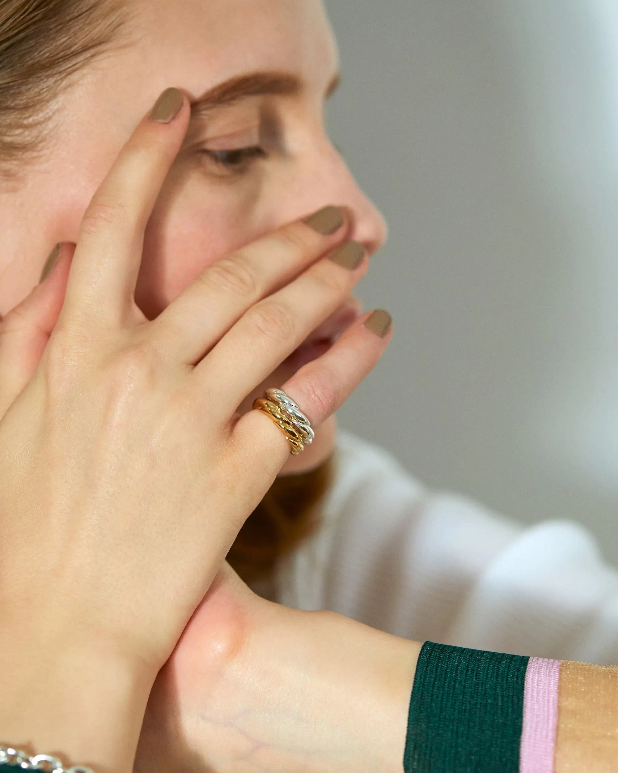 ウェーブリング(ゴールド)の着用手元アップ。指先が動くたびに奥深い煌めきを放つツイスト加工の指輪。