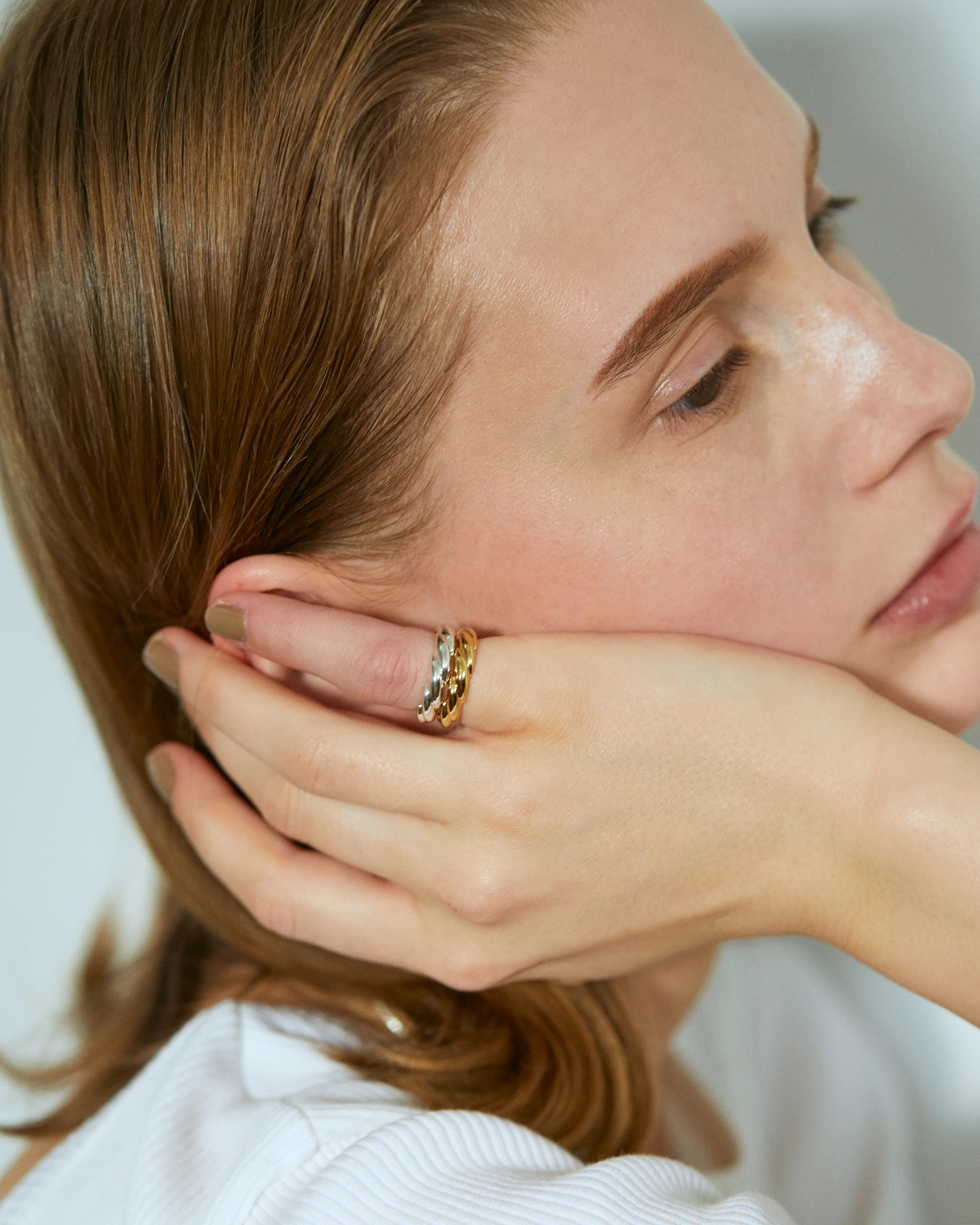 シルバーとゴールドのウェーブリングの重ね付け(レイヤード)着用画像。ペアリングとしても人気のタイムレスなデザイン。