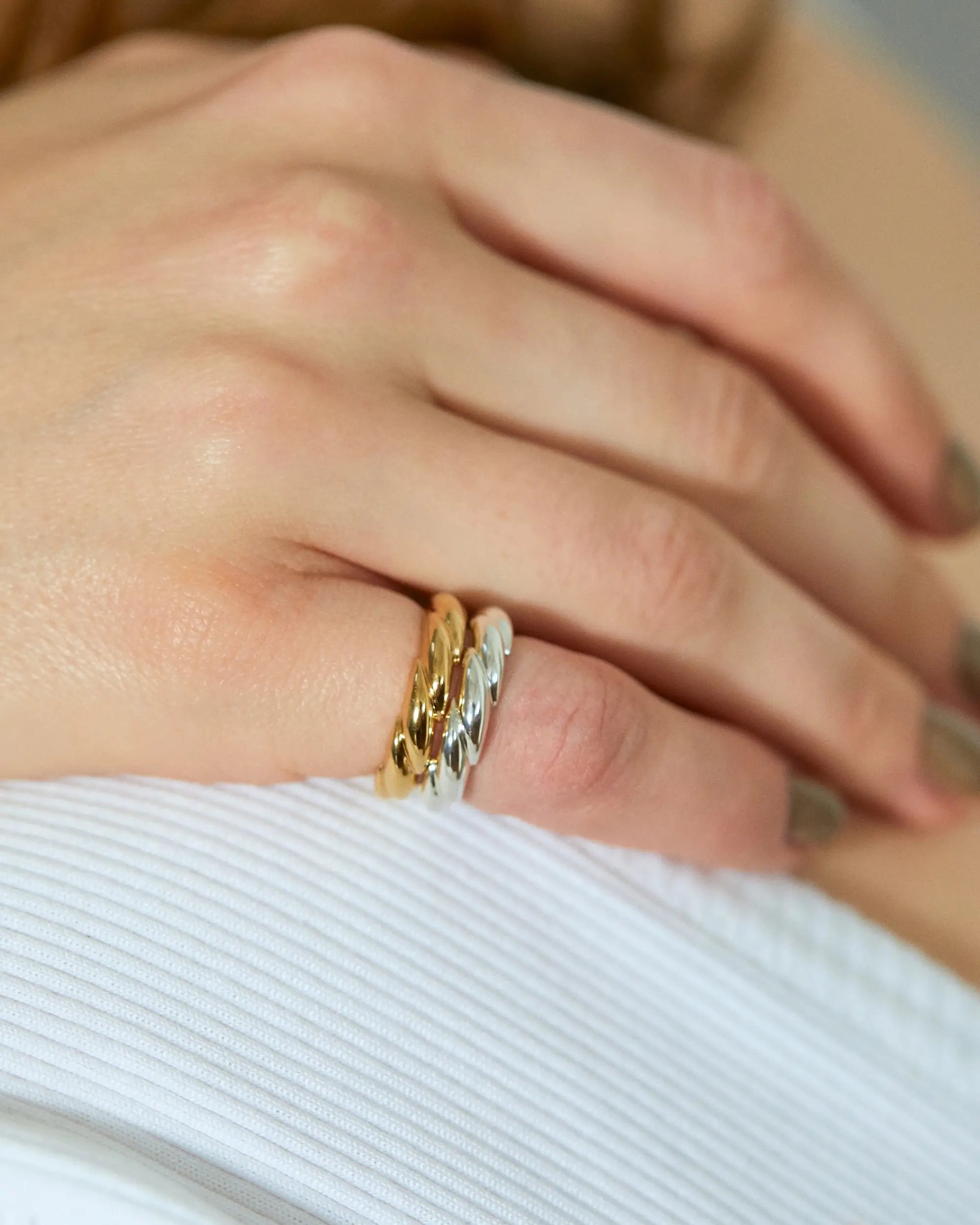 ウェーブリング(ゴールド・シルバー)を2本重ね付けした手元のアップ画像。自由なスタイリングが楽しめるユニセックスリング。