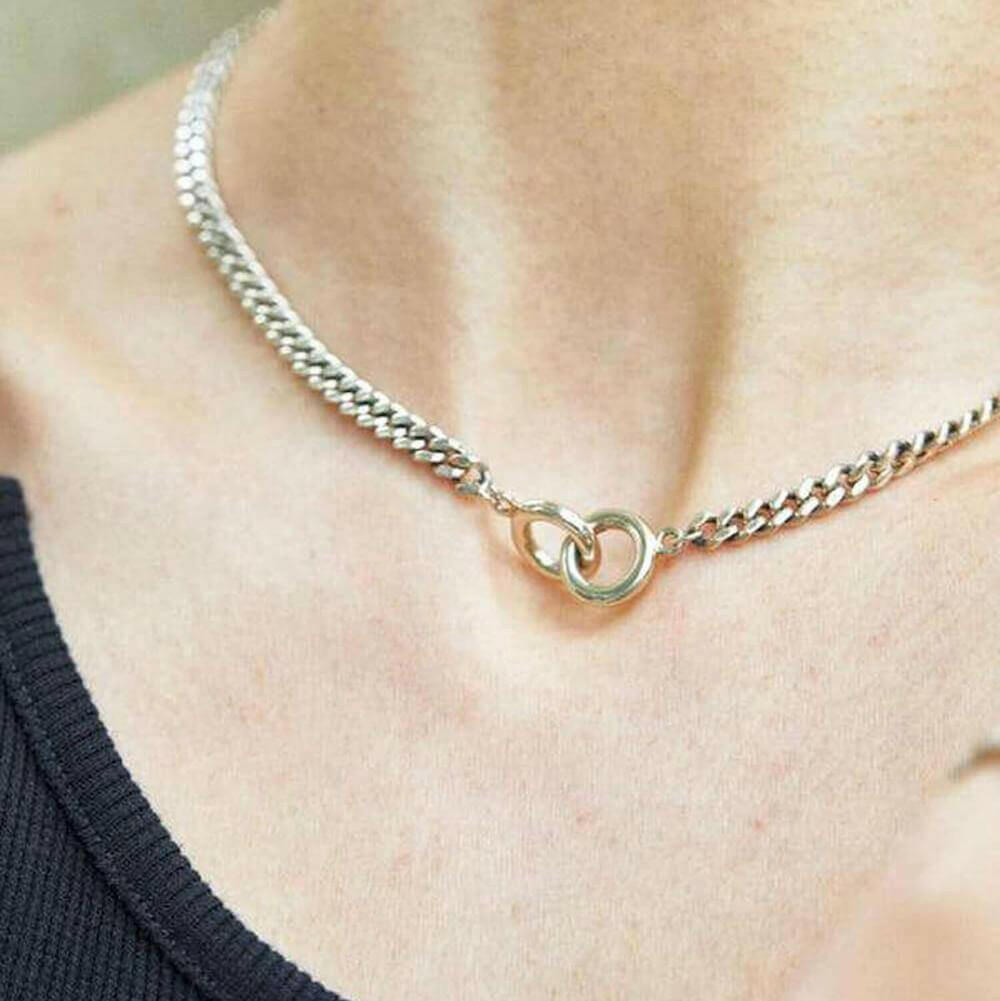 女性モデルがダブルリングチェーンネックレスを屋外で着用 寄りのカット 金属アレルギー対応シルバー925でつけっぱなし可