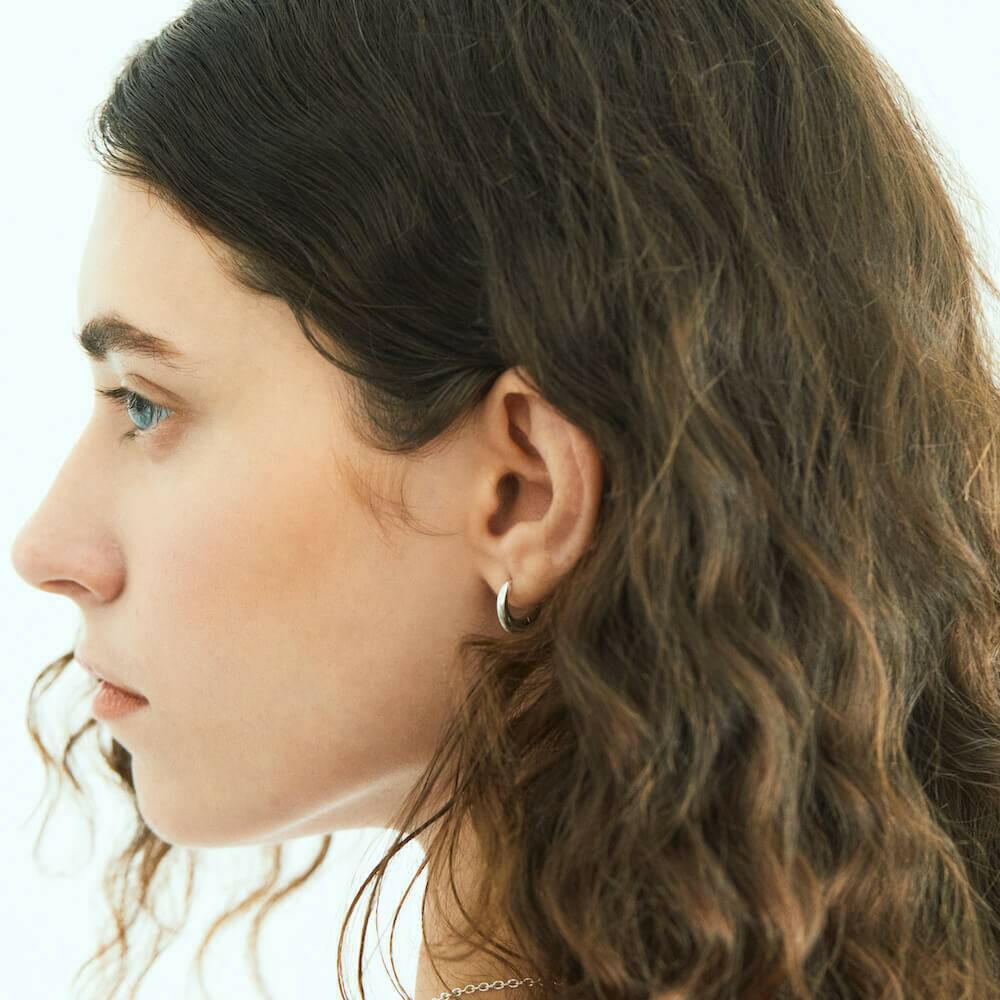 エクリプスフープピアス シルバー 横顔 | 耳たぶを包み込むようなドロップ型の立体的なフォルム