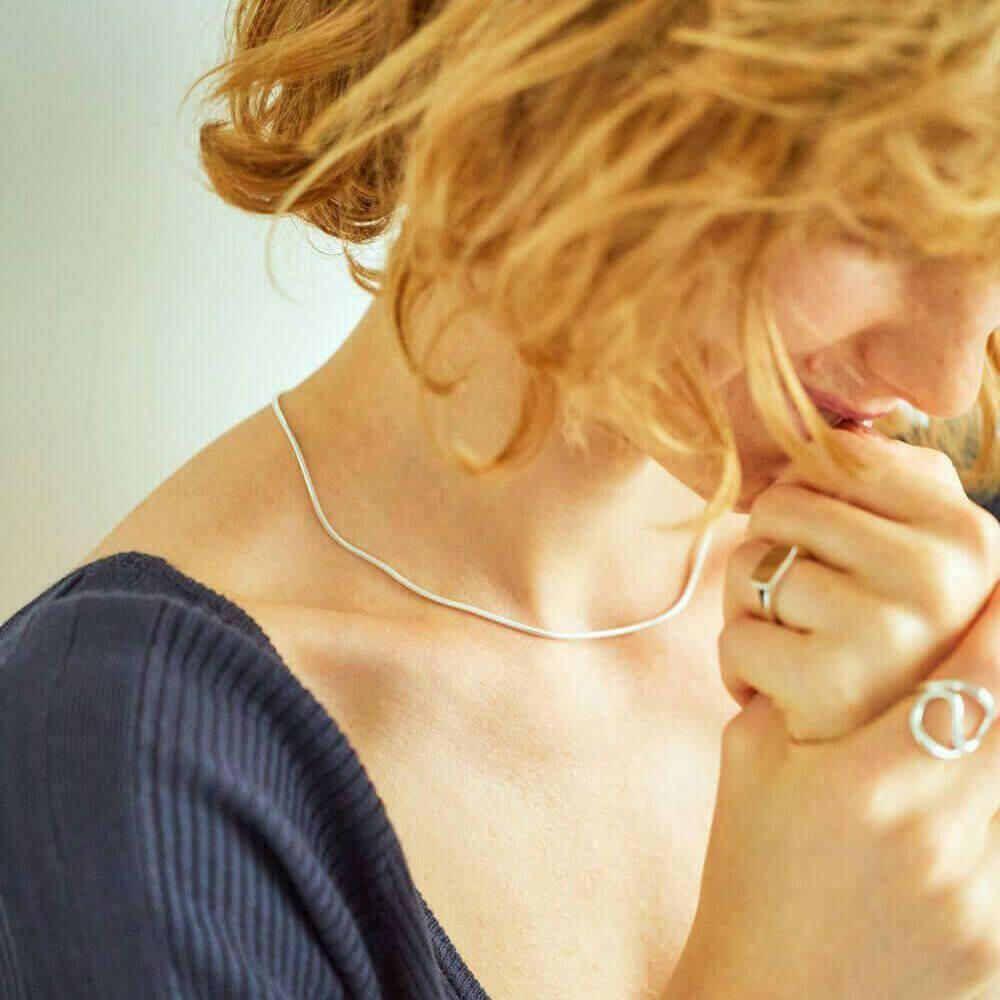 ラウンドスネークネックレス シルバー 着用画像 | 鎖骨のラインに沿って滑らかに輝くスキンジュエリー