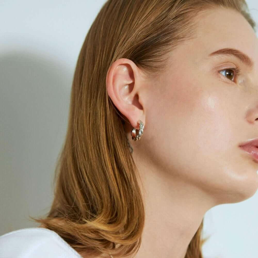 ウェーブフープピアス M シルバー 横顔 | エレガントな輝きを放つ大ぶりなツイストデザイン