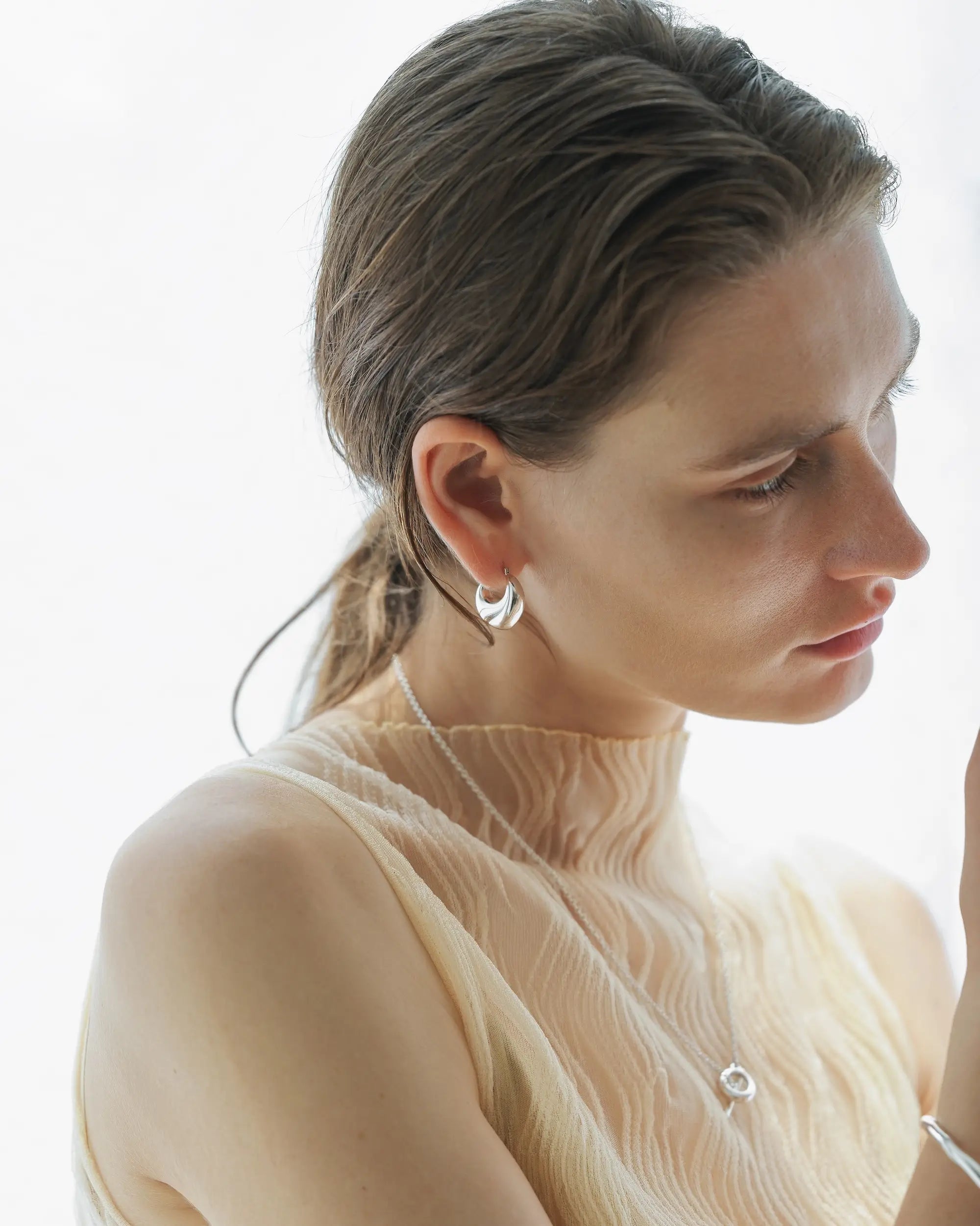 オープンハートフープピアス シルバー 横顔 | 存在感のあるボリュームが顔周りを華やかに演出
