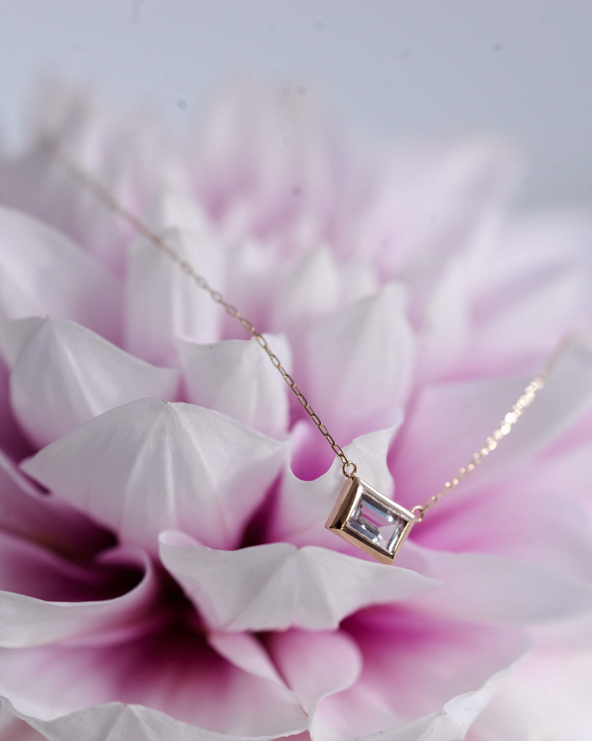 10Kゴールド バゲットカットネックレス 置き画 | ダリアの花に映える透明感あふれるホワイトトパーズ