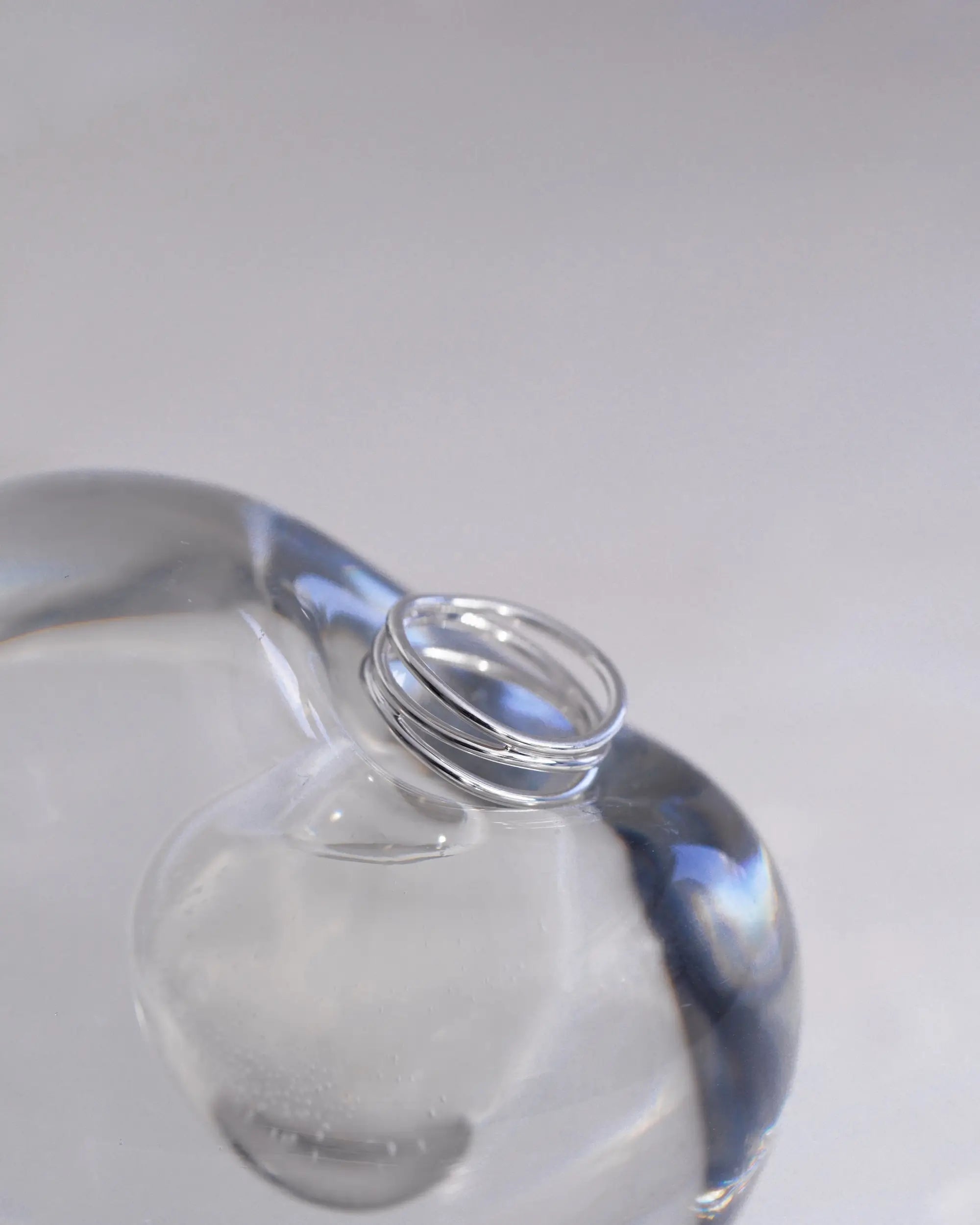 透明なガラス瓶にあしらったシルバーのウェーブリング。タイムレスで洗練されたデザインのイメージカット。