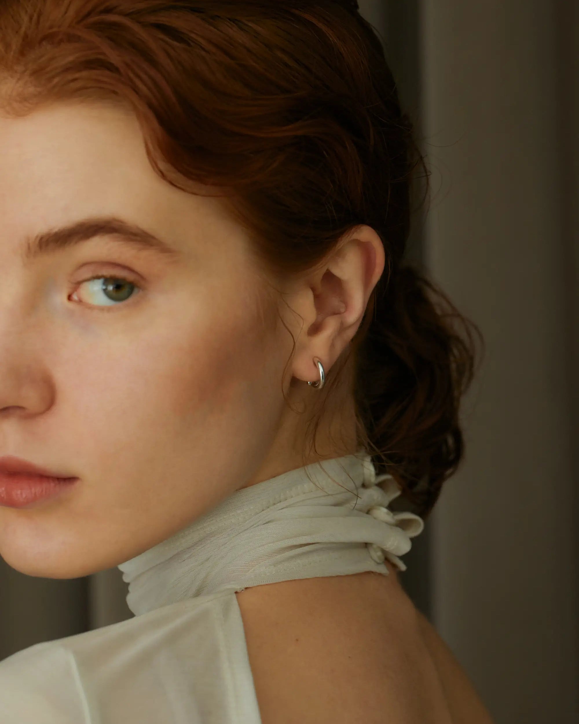 シルバー925製クラシックフープイヤリングを着用した横顔。スマートなヒンジ構造ですっきりとしたシルエット。