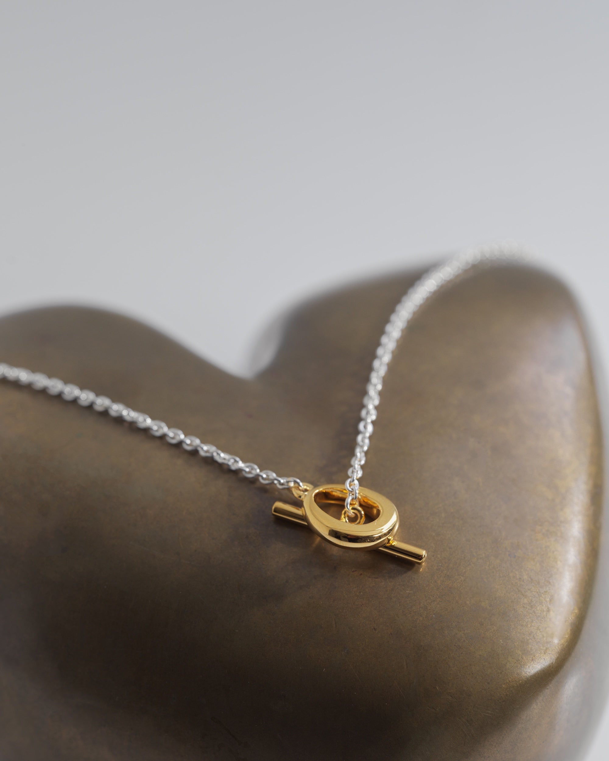 デュードロップネックレス バイカラー 置き画 | 有機的なマンテルと繊細なチェーンのバランスが絶妙な一本