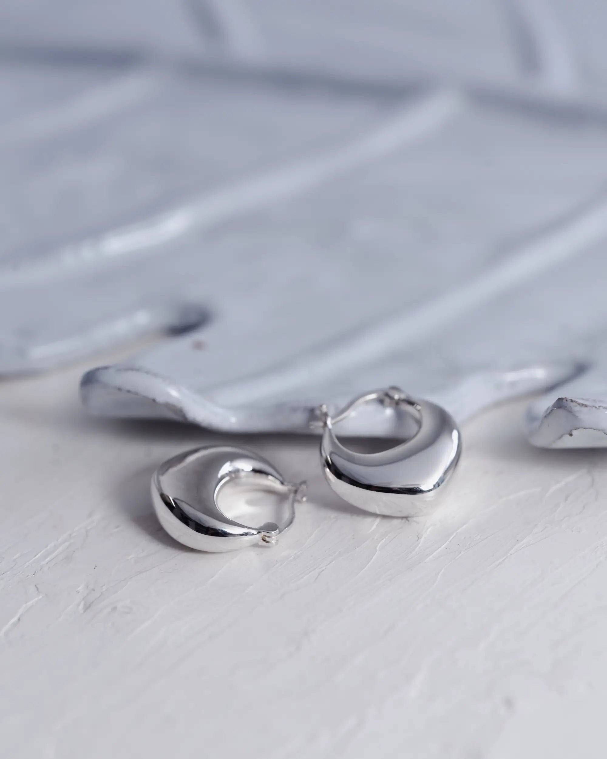 オープンハートフープピアス シルバー 置き画 | 洗練されたシルバー925の輝きとボリューム感