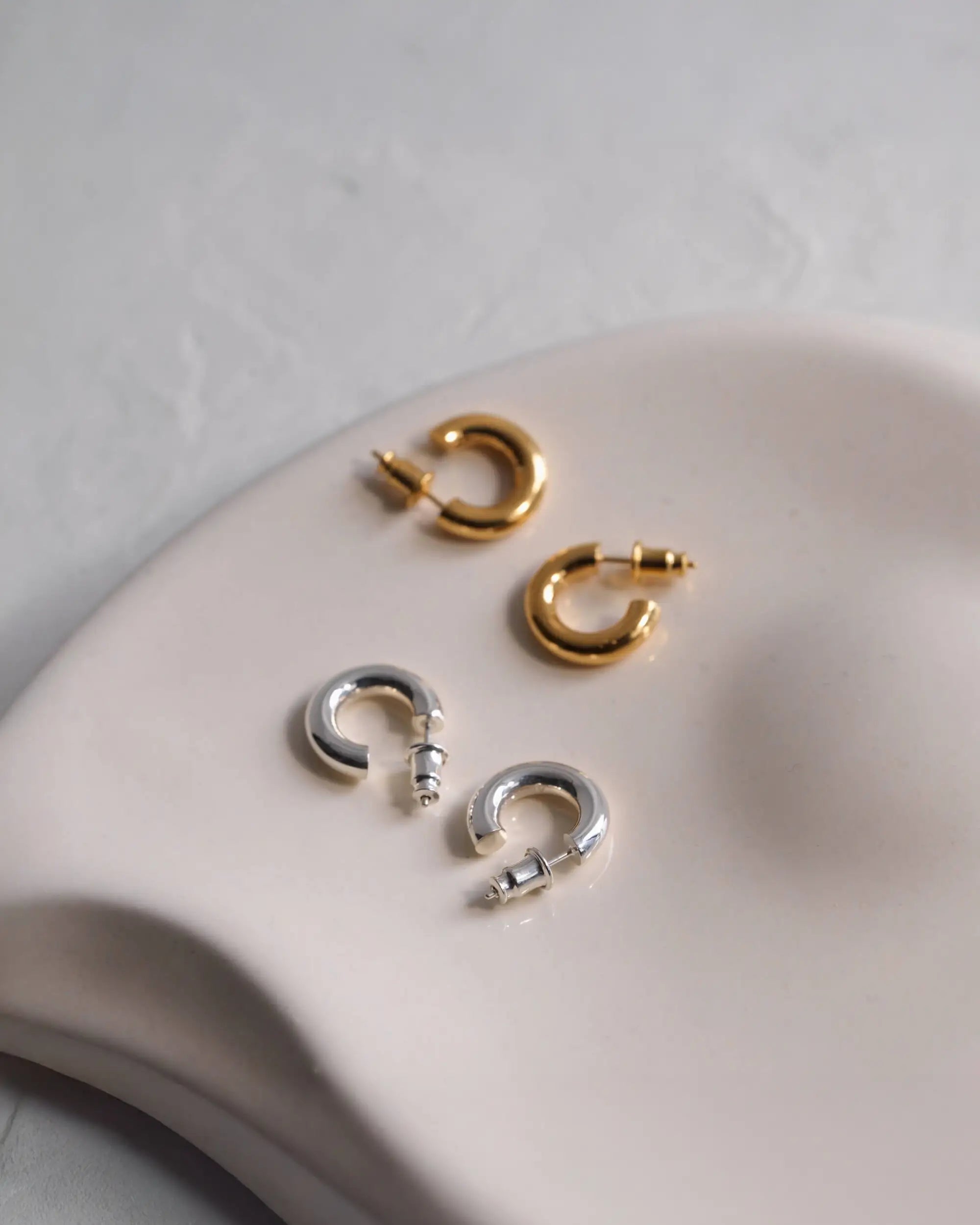 美しいトレイに並んだ小さめサイズのオーバルフープピアス S（シルバー・ゴールド）。金属アレルギー対応でつけっぱなしに最適なSilver925製スキンジュエリー。