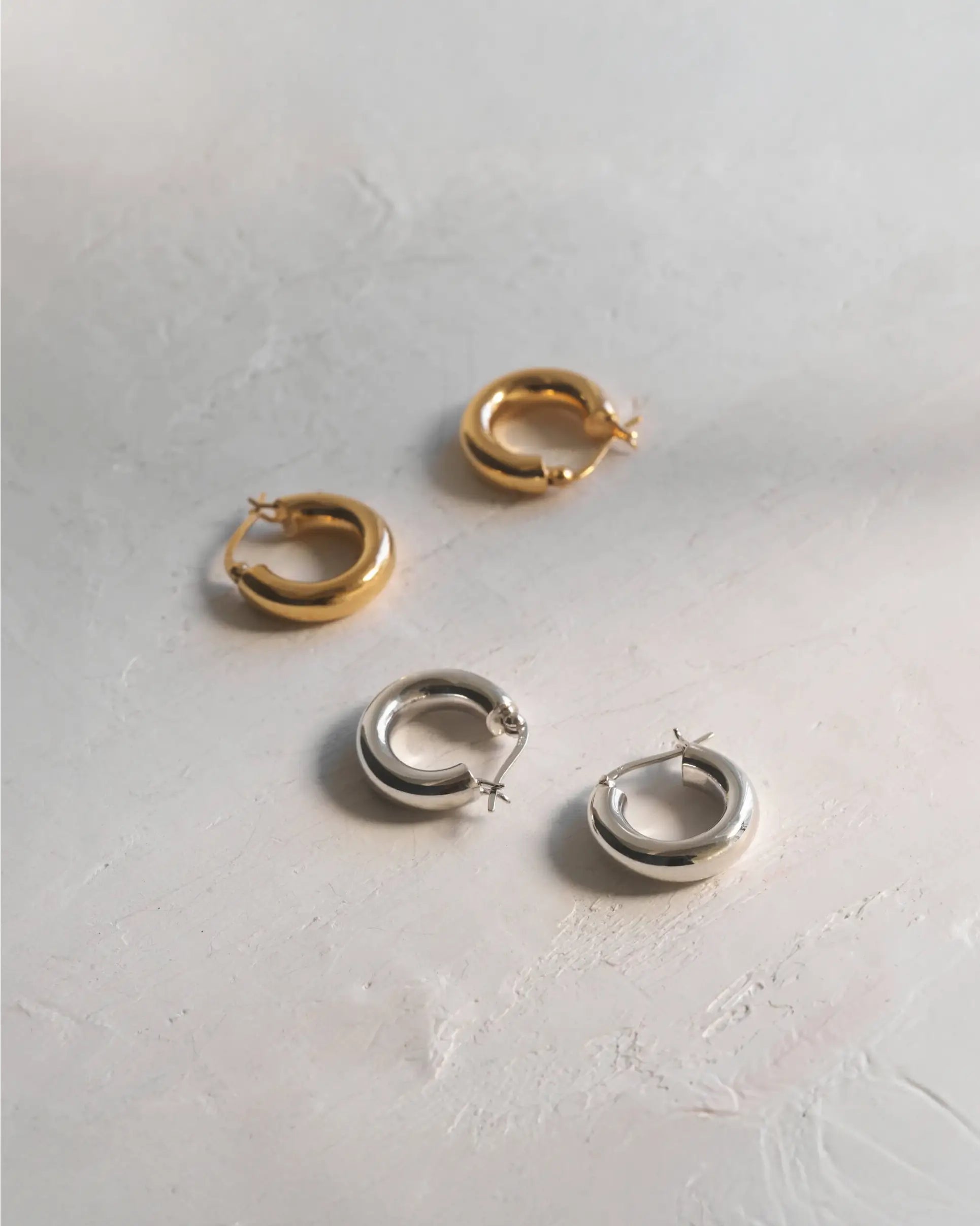 シルバーとゴールドのプランプフープピアス。大ぶりでぷっくりとした艶やかなフォルムと、つけっぱなしに最適な金属アレルギー対応Silver925素材が特徴。