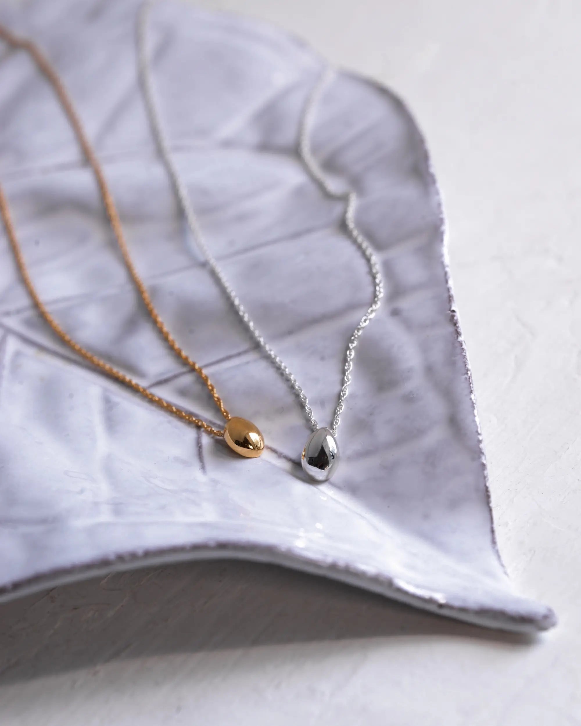 ティアドロップネックレス（シルバー＆ゴールド）商品置き画像 - 自然界の美しい曲線美を表現した雫型モチーフ
